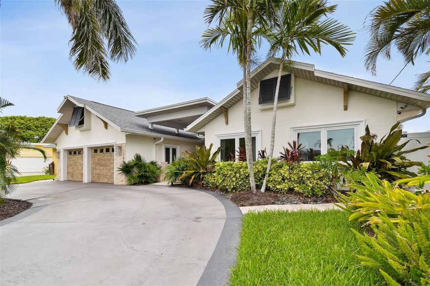 Step inside this stunning, completely renovated waterfront home and be captivated by its vaulted ceilings and open concept indoor/outdoor living. This modern 3118 square foot home is illuminated by natural light in every room. Double French doors bring the outside in and showcase the surrounding lush, tropical landscape, gas-heated saltwater pool & hot tub, boat house and tiki hut. Watch the sun rise from your private dock w/13K lbs. lift, water & power access, or enjoy the evening roasting smores around the fire. At the end of the day, relax in the serenity of the master retreat, with sitting area, custom walk in closet, and elegant spa-like ensuite bath featuring double vanities, an oversize rainfall shower with 3-way jets & handheld, and an exquisite marble fireplace. The chef’s kitchen is center stage with its 13-foot natural stone island, KitchenAid stainless steel appliances, custom range hood and beautiful overhead windows. Enjoy hosting family and friends in the expansive living room and dining area. This sprawling ranch home features European engineered hardwood floors, oversized bedrooms (each with its own ensuite bath and walk in closet), an additional hall bath with tub and separate shower, and a sun-filled office. The 2-car oversized garage with storage closet and retractable ladder for additional attic storage makes storing holiday décor a breeze. The superbly landscaped front yard features Royal palms and plenty of parking in its circular driveway. This smart home features natural gas supply for its tankless hot water heater, fire pit and pool heater. It also features reclaimed water for the lawn irrigation system, water softener, Nest thermostats, ADT security system, 2 newer AC units (2019), Ring doorbell (2023), new Roof (2022), hurricane impact windows, new pool heater (2022) and new dock (2023) along its 70-foot seawall. Most furniture and decorative items are available for sale with the home. All that’s missing is YOU living your best beach life! Make an appointment today to experience all the beauty and tranquility this magnificent home in beautiful, white-sand Clearwater has to offer.