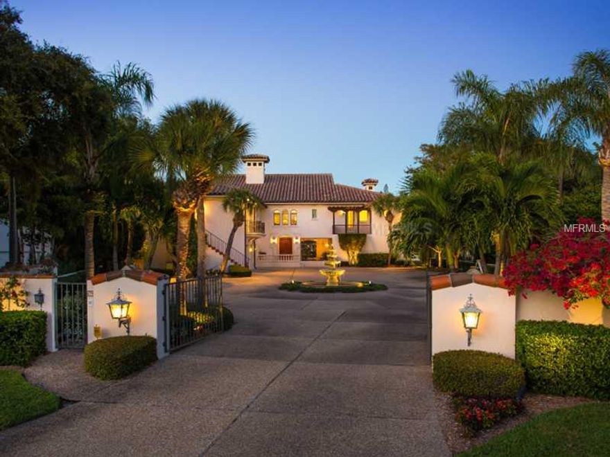 The first impression this Siesta Key waterfront estate makes upon driving through the gated entry is one of sophisticated elegance. The picturesque courtyard surrounded by a perimeter privacy wall offers you a hint of what lies within. Situated on nearly ½ an acre with 114' of coveted water frontage, custom built by Magnum Builders, the construction quality is of the absolute highest caliber featuring 50+ concrete pilings beneath the foundation which are tied to special footers that are reinforced with concrete and steel, concrete floors on the upper level and a barrel tile (2 piece) roof in which the roof trussess incorporate embedded straps into the concrete. Inside, visitors delight in fine detail choices such as opulent crown molding in the dining room, vaulted exposed beam ceilings of the living room, imported Italian travertine marble and dense artisan wood doors that secure the home. Complete with chef's kitchen, office, custom his/hers master walk-in closets and 3 guest rooms strategically positioned in a dedicated wing. The lavish heated pool and spa lords over the waterside space with a summer kitchen and al fresco dining area. The exterior is populated with fruit trees, a gazebo, herb garden and rich landscaping. The deep water dock boasts a lift to fit a 28' boat, dockage for a 50' boat, jet ski/kayak lift minutes from Siesta's North Bridge, perfect for boating enthusiasts. Features a 2 stop elevator and impressive storage areas on the lower level adjacent to the 3 car garage.