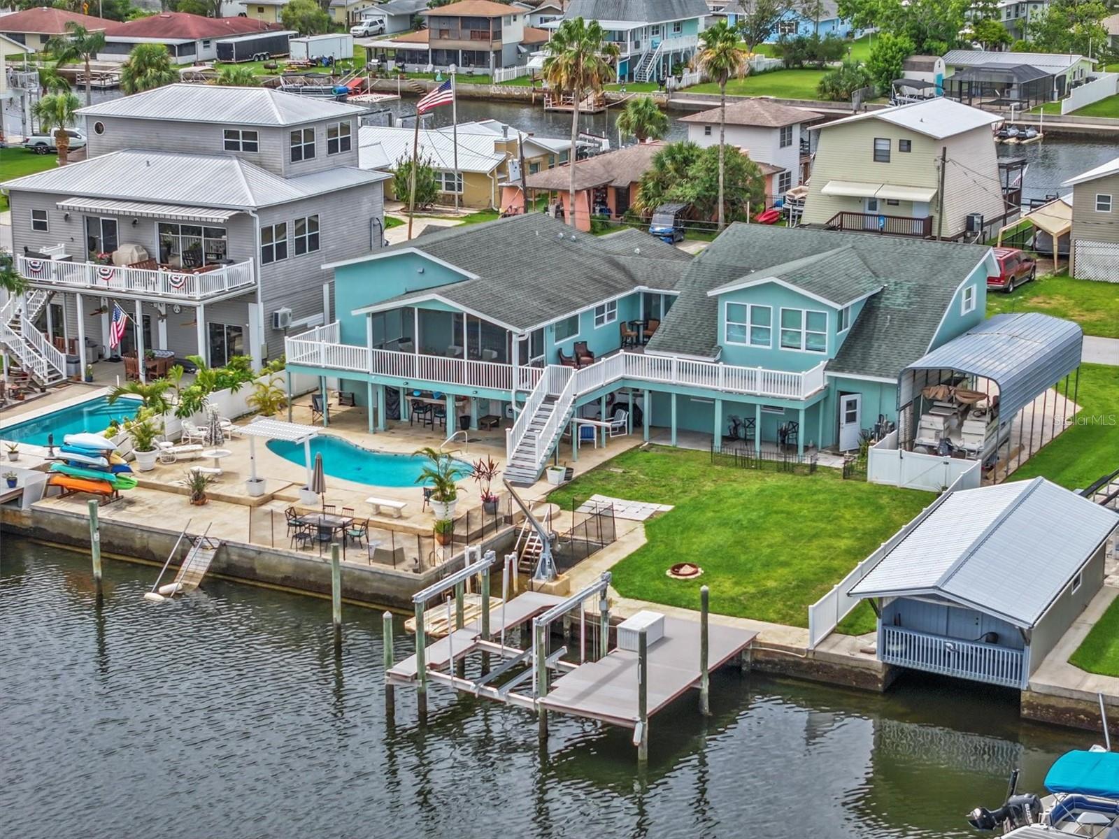 Amazing opportunity to own a 4 bedrooms and 3 bathrooms multigenerational pool home with Gulf Views and Direct Gulf Access in Hernando Beach FL!
This unique multigenerational single family pool home has 4 bedrooms and 3 bathrooms home with 2 separate units for different family members. Unit 1 is on the second floor with 2 bedrooms and 2 bathrooms with full kitchen with granite island/countertops and stainless-steel appliances. Additional features include wood flooring, updated bathrooms, screened porch with Gulf views and spa tub in the master bathroom. Unit 2 is on the second floor with 2 bedrooms and 1 bathroom with a full kitchen and living room with Gulf Views. Downstairs on the ground level has great possibilities to use a garage, storage or something else. This unique design allows family members to live their own lives within this communal property.
The backyard has 93 feet on a saltwater canal that leads directly to the Gulf of Mexico without any fixed bridges. For those family members that love water. The property has a 10,000-pound boat lift and Duratek fixed dock as well as a large inground gunnite pool with oversized stamped concrete deck, and large grass area for the family members with fur. Cover parking spot for your boat or RV.
This home is located in the Direct Gulf Access section of Hernando Beach meaning the canals behind this home are saltwater, gracefully rising and falling with the tides. This means that you enjoy seamless navigation directly to the Gulf of Mexico without encountering fixed bridges or any obstructive challenges. The convenience and freedom of unimpeded boating make this section highly sought-after for those who crave an optimal boating experience.
This section of Hernando Beach does not have an HOA meaning no deed restrictions only county does apply. So, you can keep boats, trailers, and commercial vehicles in your yard or driveway. You can have 8-foot-high privacy fences and use your home as a short-term rental if you want. This section is the most popular place to live in Hernando beach because it is the best for boating.
Welcome to Hernando Beach, a hidden gem nestled along the Gulf of Mexico, where the heart of the community beats to the rhythm of recreational fishing and boating. Tucked away down a coastal 2-lane highway with access points only from the North and South, Hernando Beach is a quiet and isolated coastal hamlet offering a unique blend of tranquility and vibrant coastal living.
While the name might suggest sandy shores, Hernando Beach surprises with its lack of a traditional beach, compensating instead with a cool coastal vibe that permeates through waterfront tiki bars, marinas, fine dining restaurants, seafood markets, and charming shops. The community is a haven for those seeking a waterfront lifestyle, with single-family homes lining saltwater direct Gulf Access canals or freshwater indirect Gulf Access canals.
In essence, Hernando Beach beckons those who yearn for an extraordinary Gulf Coast Fishing Homes Lifestyle, where the rhythms of the sea and the charms of coastal living converge in perfect harmony. Welcome to a community where isolation feels like a luxury, and the beauty of the Gulf Coast unfolds in every tide and sunset.