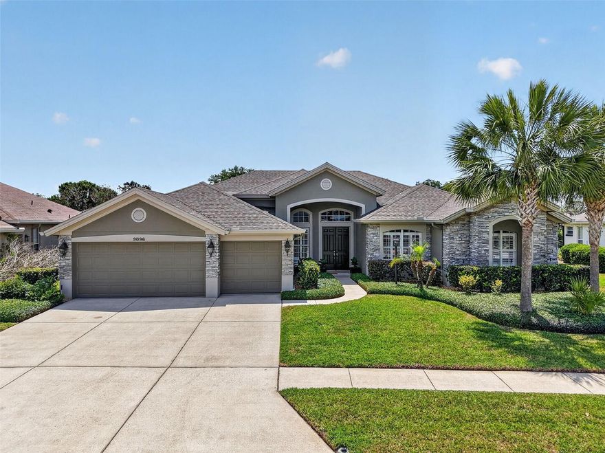 Discover this exquisite 4-bedroom pool home with a dedicated office and 3-car garage, ideally located in the sought-after Country Club of Mount Dora, a premier golfing community set against a picturesque 18-hole championship course. Residents enjoy a welcoming atmosphere with beautifully maintained grounds, a clubhouse and restaurant, community pool, and scenic walking trails. Arrive home along charming, tree-lined streets to this impressive residence, where lush landscaping, swaying palm trees, and a manicured lawn create striking curb appeal. The home’s exterior showcases rich, earthy stucco tones accented by stacked stone, with architectural details like a gabled roof, arched windows, and a grand arched entryway adding timeless elegance. Enter through double front doors into a bright, inviting interior where quality craftsmanship is evident throughout. The foyer is framed by grand columns and opens to a sophisticated living space featuring high ceilings, plantation shutters, wood-look tile flooring, and expansive glass sliders offering stunning pool views. The spacious living and formal dining rooms flow seamlessly together, perfect for entertaining guests or enjoying family gatherings. At the heart of the home, the kitchen, breakfast nook, and family room create a warm, welcoming environment. The kitchen is beautifully appointed with gleaming quartz countertops, tile backsplash, stainless steel appliances, a French-door refrigerator, dual range, and a microwave, both with air-fry capability. Additional highlights include a large prep island, walk-in pantry, breakfast bar, and poolside dining area. The adjoining family room is ideal for relaxing evenings and offers direct access to the pool area. A private, double-door office with closet, provides the perfect work-from-home setup. Conveniently located next to the primary, it would also be ideal as a nursery/fifth bedroom. The well-equipped laundry room features abundant cabinetry, a folding counter, and a utility sink. Designed with a triple-split floor plan, the home offers privacy for all. The luxurious primary suite is a true retreat, featuring a tray ceiling, abundant natural light, private pool access, and an en-suite bath with dual walk-in closets, separate vanities, a makeup station, a tiled shower, and a deep soaking tub. Two guest bedrooms share a Jack-and-Jill bathroom, while the fourth bedroom is conveniently located near a full pool bath with a walk-in shower. The 3-car garage includes a 220-volt outlet, ideal for electric vehicles or a golf cart. Step outside to your private oasis—a covered, screened lanai with a sparkling saltwater pool heated by energy-efficient solar panels. Generous covered areas provide space for outdoor dining and lounging, while a lush hedge ensures privacy. Located just minutes from shopping, dining, and the charm of historic downtown Mount Dora, this exceptional property offers the perfect blend of luxury, comfort, and convenience.