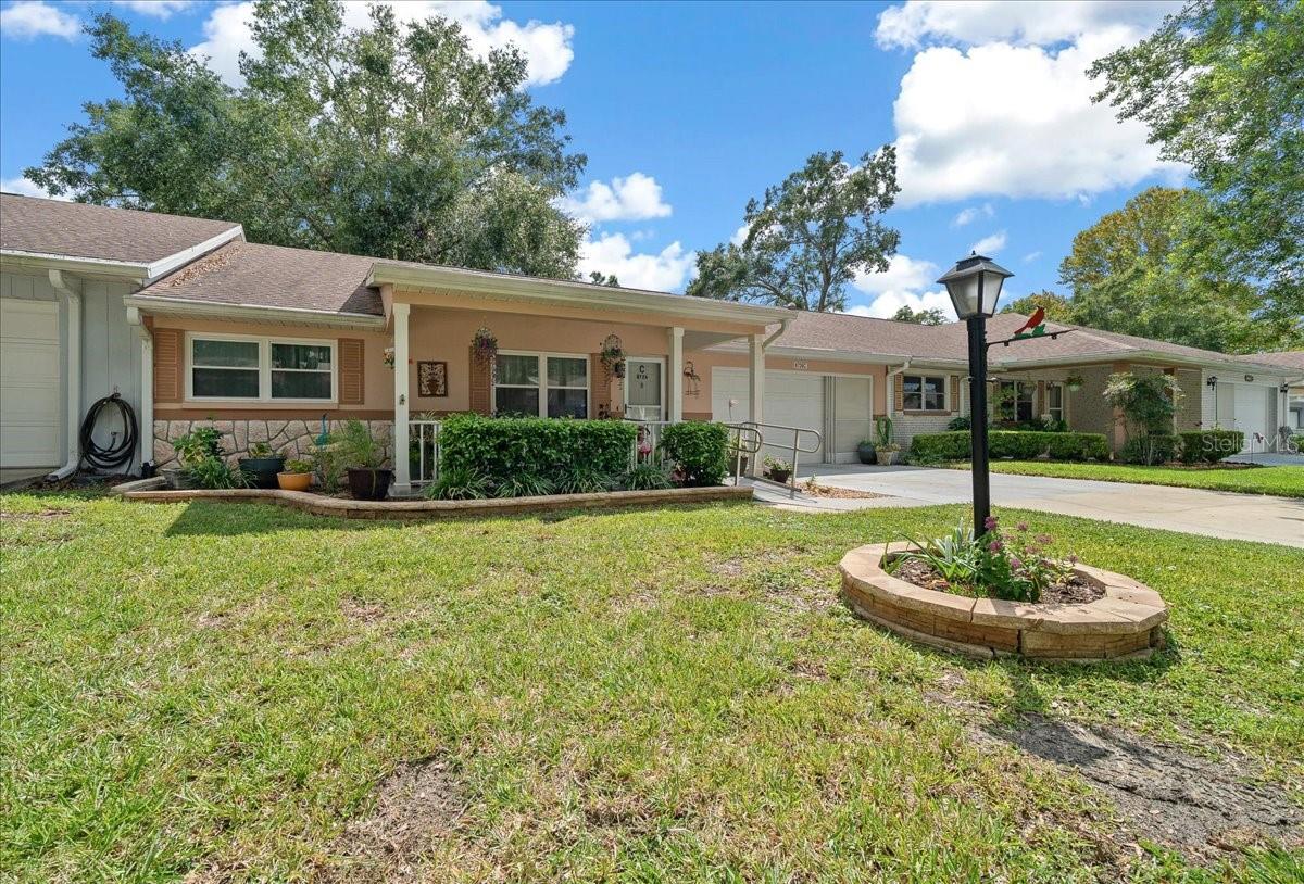 Come discover this inviting 2-bedroom, 2-bath Montgomery Villa with a 2-CAR GARAGE in the sought-after 55+ community of On Top of the World, Ocala, FL. Peace of mind comes with major updates already done—roof (2018), HVAC (2018), and windows (2007). Seller is also offering the option to purchase most of the furnishings for an easy move-in (ask for list, and to be sold separately).
Relax on the spacious front porch where you will feel gentle breezes and hear bird songs. The ramped entry welcomes you into a home filled with natural light and warmth. Inside, enjoy the beautiful flooring throughout—the only carpet is in the closets. Two spacious living areas (one formal and one more relaxed) invite you to entertain guests, share meals, curl up with a good book, or watch your favorite show in comfort. A bonus room off the kitchen makes an ideal spot for a sunny office, creative craft space, or quiet study. The back patio offers a place to BBQ or relax with friends and cocktails.
The large primary suite includes a spacious walk-in closet and a bathroom refreshed with updated cabinetry, lighting, and paint. The guest bath has been updated offering comfort for visitors, and the solar tube bathes the space in plenty of natural light. At the heart of the home, the kitchen gleams with newer cabinets, countertops, lighting, and a brand-new refrigerator (2024). A solar tube also provides natural daylight, reducing the need for electric lights.
In the garage, sliding screen doors let you savor the breeze while you work or relax, and the oversized space easily fits both a car and a golf cart. From here, a short ride takes you to sparkling pools, bustling recreation centers, a dog park, pickleball and archery fields, Publix for everyday needs, and lively Town Square events where neighbors gather in the evenings. Seller is also leaving the washer & dryer for your convenience.
The HOA makes life simple by covering lawn care, exterior paint every 7 years, roof repair, exterior maintenance and insurance, trash and recycling, 24/7 monitored gates and basic cable. Ideally located near I-75 with quick access to Gainesville, Orlando, and Tampa. Close to the World Equestrian Center, medical care/hospitals, shopping, and not far from downtown Ocala. Clean, comfortable, and move-in ready, this well-kept villa offers a lifestyle as relaxed as it is active. Don’t miss your chance to make it yours—schedule your showing today!
