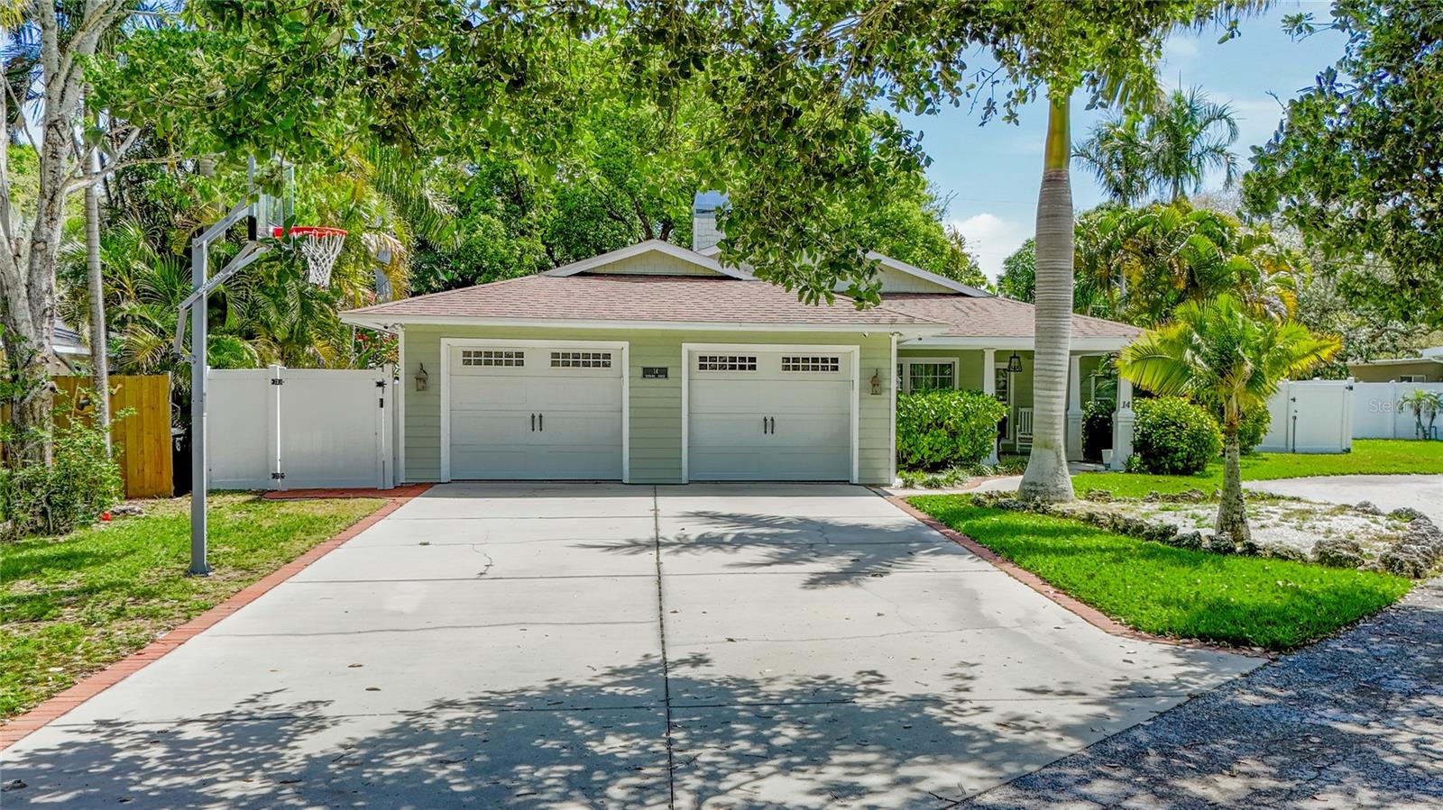 Live in the heart of Belleair and experience the charm of this beautifully updated 3-bedroom, 3-bathroom home offering over 2,200 sq. ft. of stylish living space. A welcoming front porch sets the tone, perfect for morning coffee or winding down in the evenings. Step inside to find soaring ceilings, rich wood floors, and a cozy wood-burning fireplace that anchors the open-concept living area. The gourmet kitchen is a true centerpiece, featuring custom wood cabinetry, sleek granite countertops, a double sink with a touch faucet, and high-end Frigidaire Professional Series appliances—all seamlessly integrated with bar seating for casual dining and entertaining. The thoughtful split-bedroom layout provides optimal privacy. The spacious primary suite offers plantation shutters, a walk-in closet, and a spa-inspired en-suite bath. Two additional bedrooms share an updated full bathroom, ideal for guests or family. Step outside to enjoy a private, fenced backyard shaded by mature oak trees, complete with a wood deck—perfect for outdoor dining or relaxing under the canopy. Ideally located just minutes from upscale shopping, top-rated restaurants, award-winning Gulf beaches, and two premier golf courses, this Belleair gem offers the perfect blend of comfort, convenience, and lifestyle.
