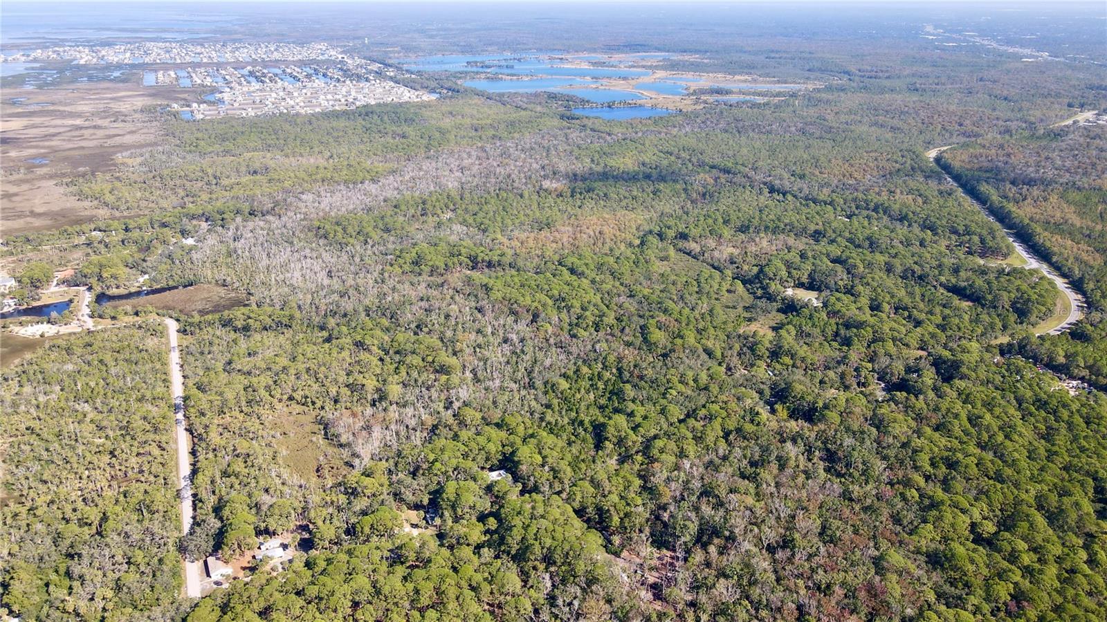 The opportunity is to purchase approximately 28 acres located in Aripeka (Hernando County). The property is heavily wooded and boasts significant frontage on Indian Bay Road (1,918 feet), ensuring easy accessibility. It is estimated to have approximately 15.37 acres of wetlands. Water is to the property, and sewer is located 1.6 miles down Osowaw Blvd. The parcels are zoned AG (Agriculture) with a future land use of Conservation, offering a variety of potential uses. These include opportunities for recreational activities such as hunting and hiking, building private residences, or preserving the natural landscape.
The property is located at 1490 Indian Bay Road in Aripeka in southern Hernando County. Aripeka is a peaceful, historic town on Florida's Nature Coast, nestled between the Gulf of Mexico, marshes, and natural springs. The town's tranquil, laid-back atmosphere is reflected in its scenic streets, where fishing from bridges and enjoying the surrounding natural beauty are common activities. The site is two miles away from US Highway 19, where local shops, medical, and restaurants are located. Given its close proximity to the highway, it is commutable to nearby cities: Weeki Wachee (12 minutes), Spring Hill (20 minutes), Brooksville (35 minutes), Tarpon Springs (40 minutes), Homosassa (40 minutes), Crystal River (50 minutes), and Tampa (1 hour). Additionally, the property can easily access nearby recreational destinations, including Weeki Wachee Preserve, SunWest Park, Pine Island Park, and Cabot Citrus Farms.
