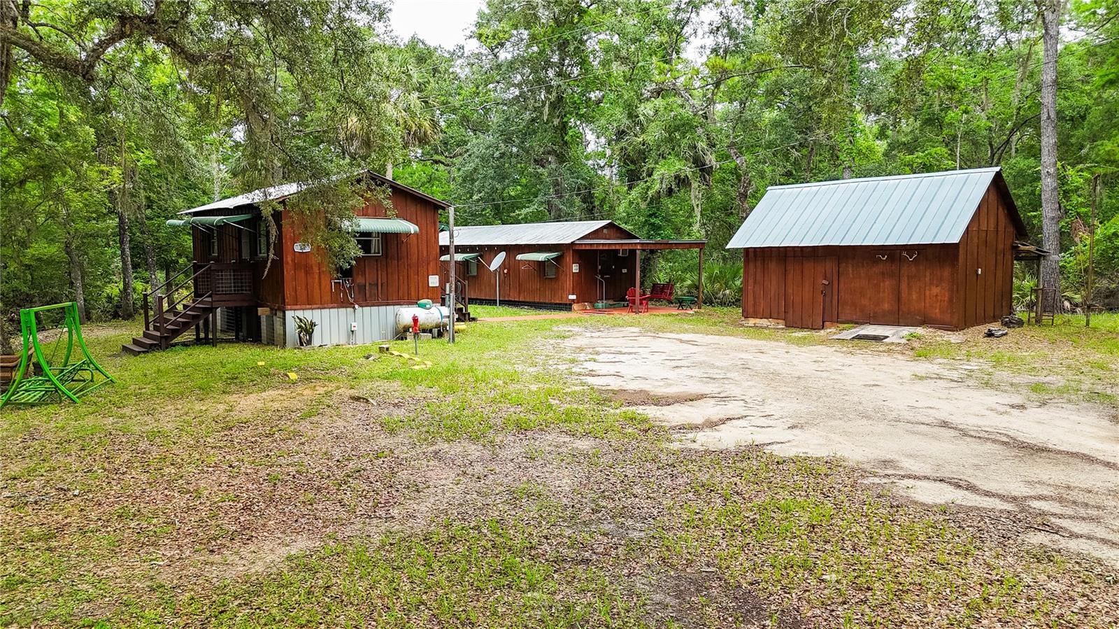 Escape to your own retreat of Old Florida with this rare riverfront in Gulf Hammock, offering over 500 feet of pristine frontage on the Waccasassa River. Nestled on 1 acre and surrounded on three sides by water, this fully furnished, turn-key, camp-style getaway features a cozy main cabin with a full kitchen, living area, queen size bed and bath, plus a separate bunkhouse with three additional beds, sofa bed & a second full bath, and stackable washer/dryer—this property comfortably sleeps up to 7 guests. Great for fishing, hunting, or boating (just minutes from the Waccasassa Park Boat Ramp), the property also includes a storage/workshop, firepit pavilion, picnic tables, and canoes for endless outdoor & enjoyment. Located just 30 minutes from Cedar Key and Crystal River, this is the perfect personal escape or vacation rental opportunity in the heart of Florida’s Nature Coast.
