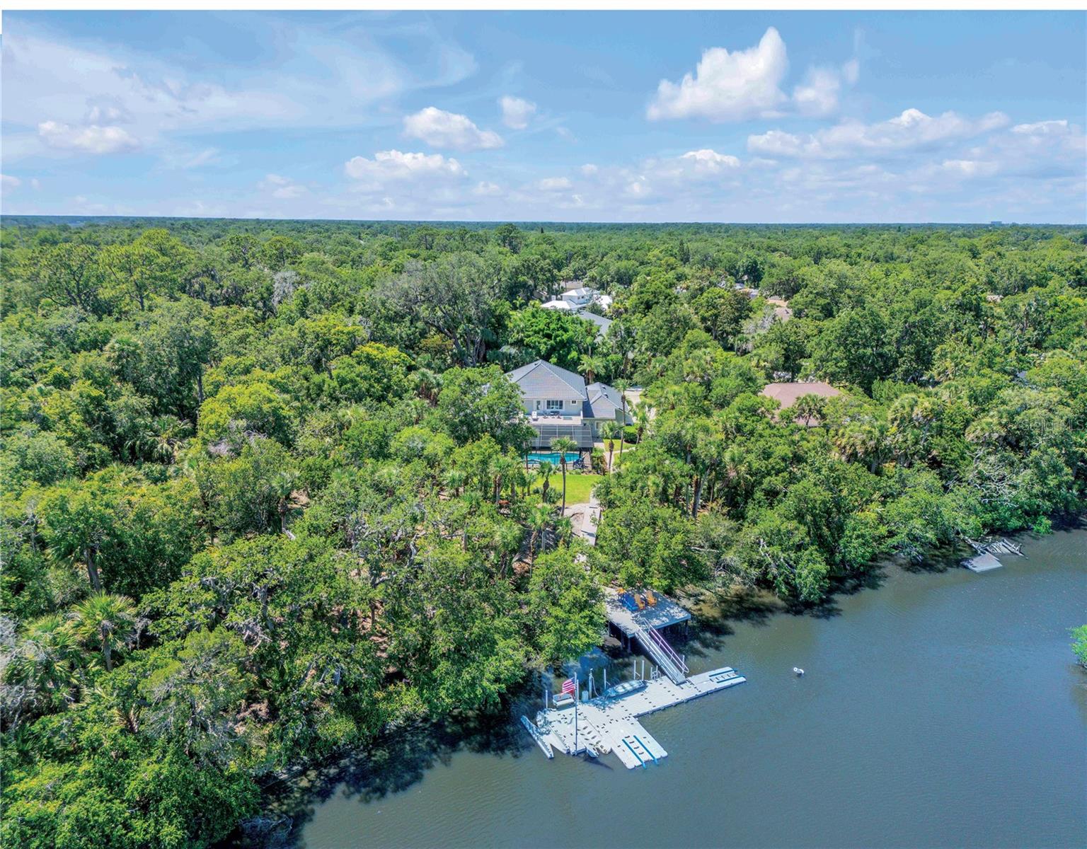 Stunning 5 Bdr, 4 1/2 Ba, waterfront pool estate home at 6325 Palmas Bay, located in the gated Palmas Bay Club within the Riverwood community of Port Orange. Positioned on a semi private cul de sac along Spruce Creek with direct access to the Halifax River and Intracoastal Waterway, ideal for boating enthusiasts. This home features a circular driveway, lush landscaping, and a 3 car garage. Inside the home is a grand foyer, formal dining, spacious kitchen with island and breakfast nook, and a large living room with gas fireplace. Sliders open to a screened outdoor living area, summer kitchen, and fully screened in pool. The first floor includes the primary suite, pool bath, laundry, and media room. Upstairs offers three bedrooms, two full baths, and a divided sitting area. A paver walkway leads to a large deck and floating dock, perfect for fishing, relaxing, or launching your boat. Located minutes to beaches, dining, shopping, and top rated schools in Port Orange. POF/Pre-approval for showings.