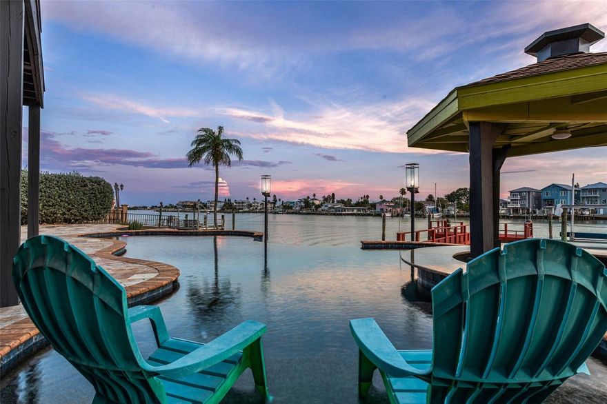 You are going to love coming home to this gorgeous WATERFRONT home on one of the widest parts of the intercoastal waterway, minutes away from John's Pass Village & the Gulf of Mexico.  This home is HIGH & DRY AND NEVER FLOODED and has 100' of water frontage on over a QUARTER ACRE lot! You will enjoy taking in the panoramic water view in the beautiful master suite overlooking all of the action or while enjoying a dip in the heated salt water INFINITY pool with a swim up tiki bar, so you can enjoy a cocktail while you take in the sunsets and watching dolphins swim in your backyard. You will be impressed by the ONLY Mid Century Modern beauty on Crystal Island with zero scape front and back yard featuring exotic cactus & succulent drought resistant gardens and brand new turf. Entering the house you will love the impressive foyer and entry way with beautiful Brazilian cherry wood and Travertine tile flooring throughout. Entertaining will be a breeze with a large, open living area transitioning to the dining room and kitchen with its own eat in area overlooking the pool and intercoastal waterway. As you step down to the family room you will be impressed with the gorgeous water views through the triple set of sliding doors with its own wet bar with wine and beverage coolers, ice maker and bar seating area as well as a beautiful gas burning fireplace! Invite family and friends over for a cook out in the expansive back yard where you can soak in the hot tub or take a dip in the heated pool with waterfall feature, a gas burning firepit and tiki torches! The master bedroom is where you will really love taking in the wide open views of the waterway with a giant separate en suite with programmable Hunter Douglas blinds or take in the fresh sea air on the large open second floor balcony. The HUGE owners bedroom also features another wet bar, mini fridge, his and her vanity sinks, a large walk in closet with built ins, a custom shower with multiple heads and zones, beautiful Brazilian cherry wood flooring and light fixtures. Both the second and third bedrooms are located on the second floor. Boaters and fishermen will love this home with its deep water GIANT dock with electric, fresh water and a large electric boat lift.  This home offers so much besides the locale and wonderful waterfront views like a BRAND NEW roof, GENERAC whole home generator, the largest SOLAR SYSTEM allowed in a residential property, 500 gallon underground propane tank, whole home water softener/filtration system, reverse osmosis system in kitchen, a separate office area on the upstairs landing, stainless steel appliances with a gas range, 2 HVAC units, two laundry closets and a laundry chute! If you ever have the desire to leave your beach oasis (why would you??), it's just minutes to all of the boating, fishing, swimming, shopping, dining, and nightlife that Pinellas county offers or if you feel more adventurous make the short drive across the bridge to Tampa where you can easily get to to I-75, the crosstown Expressway and I-4 so you can get to USF, MacDill AFB, Busch Gardens, Disney World, Universal Studios, or all of the wonderful Championship sporting events that Tampa has offer at Raymond James Stadium, Amalie Arena and Tropicana Field or spend the day boating or just relaxing on our world famous beaches.Make an appointment today for a private tour of this beautiful home before it's gone!