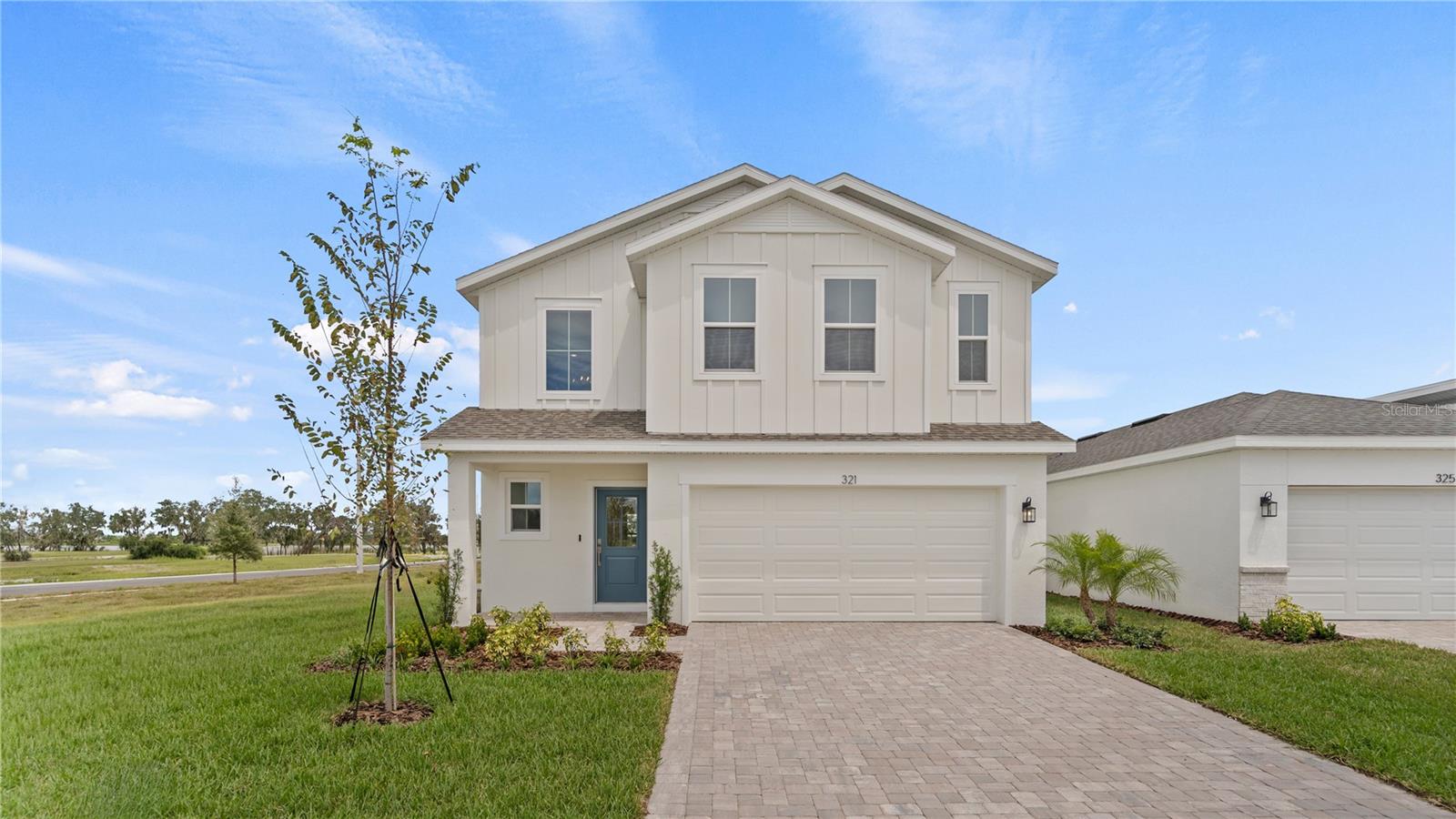 Welcome to the beautiful Naples floor plan, a spacious 4 bedroom, 2.5 bath home perfectly situated on an amazing corner homesite with a charming farmhouse elevation. As you enter, you are greeted by soaring two-story ceilings that create a grand and inviting entrance. The hallway leads you past a convenient half bath and into an open-concept living space where the kitchen, dining, and living areas flow seamlessly together, ideal for entertaining family and friends. The kitchen features elegant quartz countertops, stylish gray cabinets, and tile flooring throughout the main living areas. Just off the living room, the primary suite is filled with natural light from two large windows and offers a private retreat with a spa-like bath that includes dual vanities and a beautifully tiled shower. From the living area, step outside to a covered lanai that opens to a generous backyard, perfect for outdoor gatherings or relaxing evenings. Upstairs, the home opens to a spacious loft, creating the perfect space for a second living area, playroom, or home office. Three additional bedrooms, each with its own walk-in closet, and a full bath with dual vanities complete the thoughtful design of this home. The Naples combines modern finishes, functional spaces, and timeless style, making it the perfect place to call home.