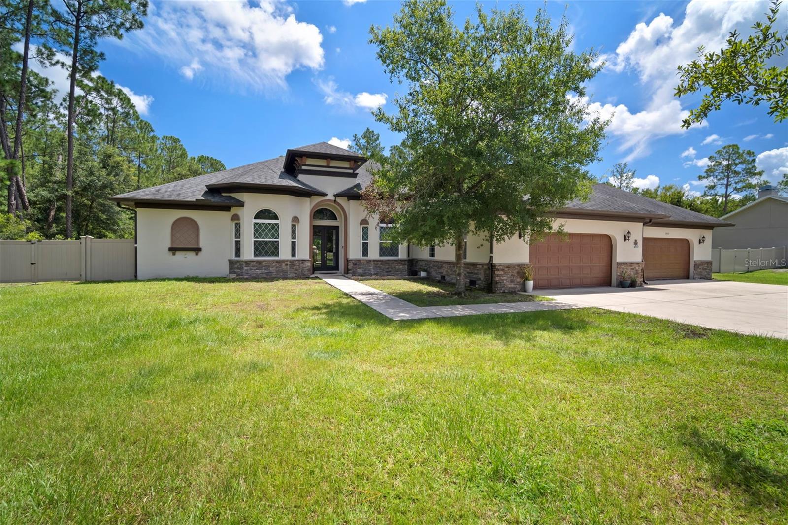 Live Like Royalty in This Stunning Wesley Chapel Pool Home! Experience luxury and functionality in this spacious, split floor plan home with soaring tray ceilings and three private wings designed for comfort and privacy. The open-concept layout features a grand common area with a gourmet kitchen, quartz countertops, grey stainless appliances, and an oversized island that flows into the expansive family room, formal dining area, and breakfast nook with built-in desks. Pocket sliding doors open to a tropical screened-in pool paradise with waterfall, grotto, and beach walkout.
The master suite offers pool access, dual walk-in closets, and a spa-like bath with an immense shower, dual sinks, and private toilet room. A guest suite sits at the front of the home with its own ensuite, while a third wing features an additional bedroom with a large walk-in closet, a full bath (also serving the pool), and a temperature-controlled bonus room or office.
A true highlight is the massive 6+ car garage, with ceilings tall enough for lifts, utility sink, walk-up attic with ample storage, and a rear-facing door for golf cart or lawn equipment. Additional perks include a spacious laundry room with sink and folding area. Just minutes from I-75, The Shoppes at Wiregrass, Tampa Premium Outlets, Busch Gardens, USF and more!