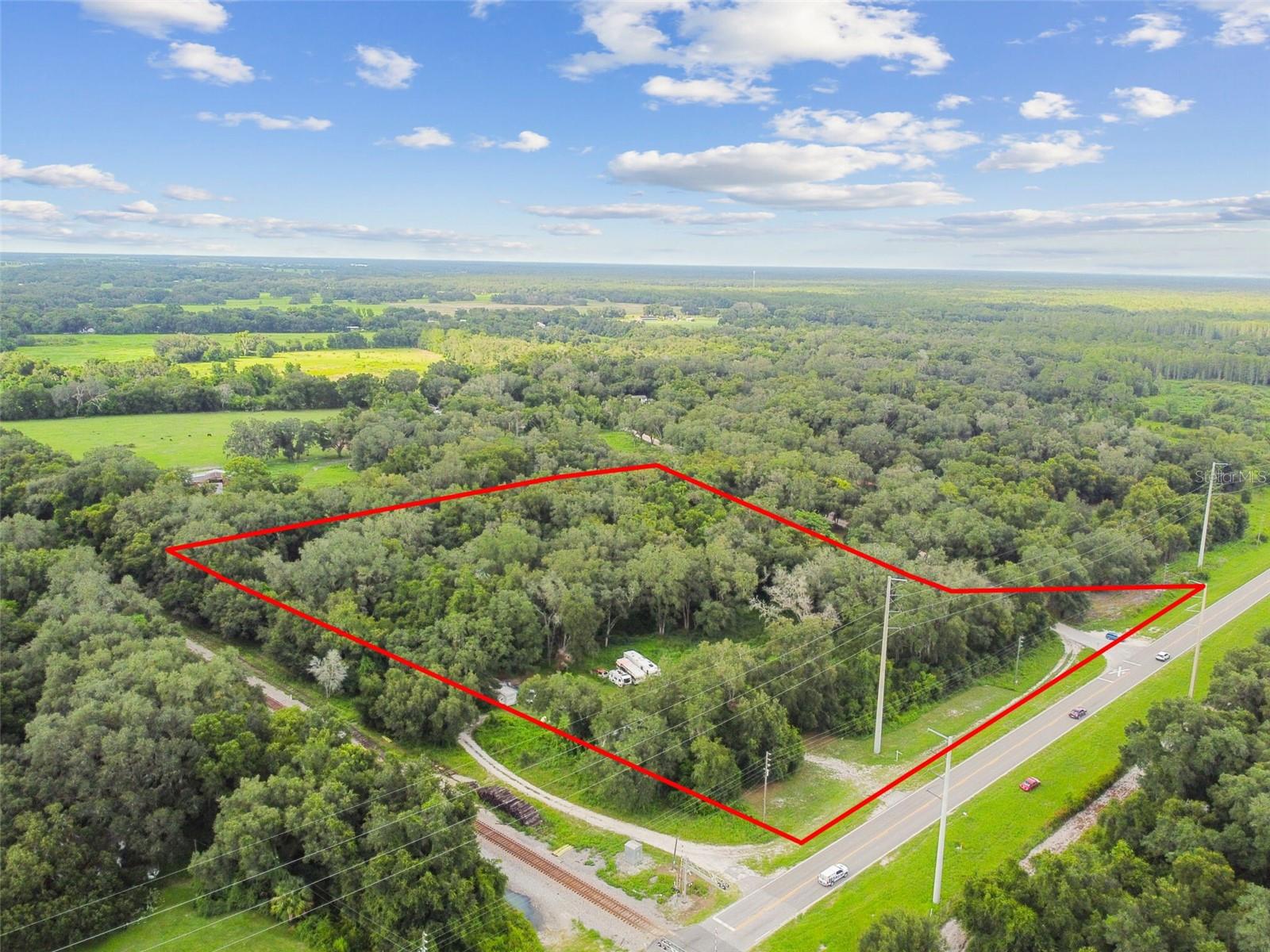 The Entrance to the Upper Hillsborough Wildlife Management Area is ACROSS the street!! It spans more than 5,000 acres along the picturesque Hillsborough River, just east of Zephyrhills on County Road 54 in Polk and Pasco counties. People can go hunting, fishing and camping. For recreation the most popular route for bicycling and horseback riding is the unpaved loop road south of CR 54, which winds through pine flatwoods. Side trails branching off this main road offer additional access for hikers and hunters. Horseback riding is not allowed during hunting seasons but is allowed at other times with a free day-use reservation from the Southwest Florida Water Management District. The buyer could potentially subdivide the 5.75 acres into five lots afterwards. The property can be purchased as a primary residence with a low down payment conventional loan because there's a 2 bedroom, 2 bathrooms manufactured home that's anchored to the ground. You can't find any other property right on CR 54 with 5.75 ACRES. You'll only find this amount of acreage on side streets. It has 706 feet of DIRECT FRONTAGE on County Road 54. The front of the property has the potential of being rezoned to commercial, a mini-mart store could be built to service the 1,109 families that live in Forest Lake Estates which is less than 2 minutes away. A new subdivision will be built on the intersection of Chauncy Road and CR 54 shortly. The nearest shopping center or gas station to them are over two (2) miles away. There are two wells and two septic tanks on the property. All other RV vehicles will be removed by the sellers. CASH or Conventional loan.