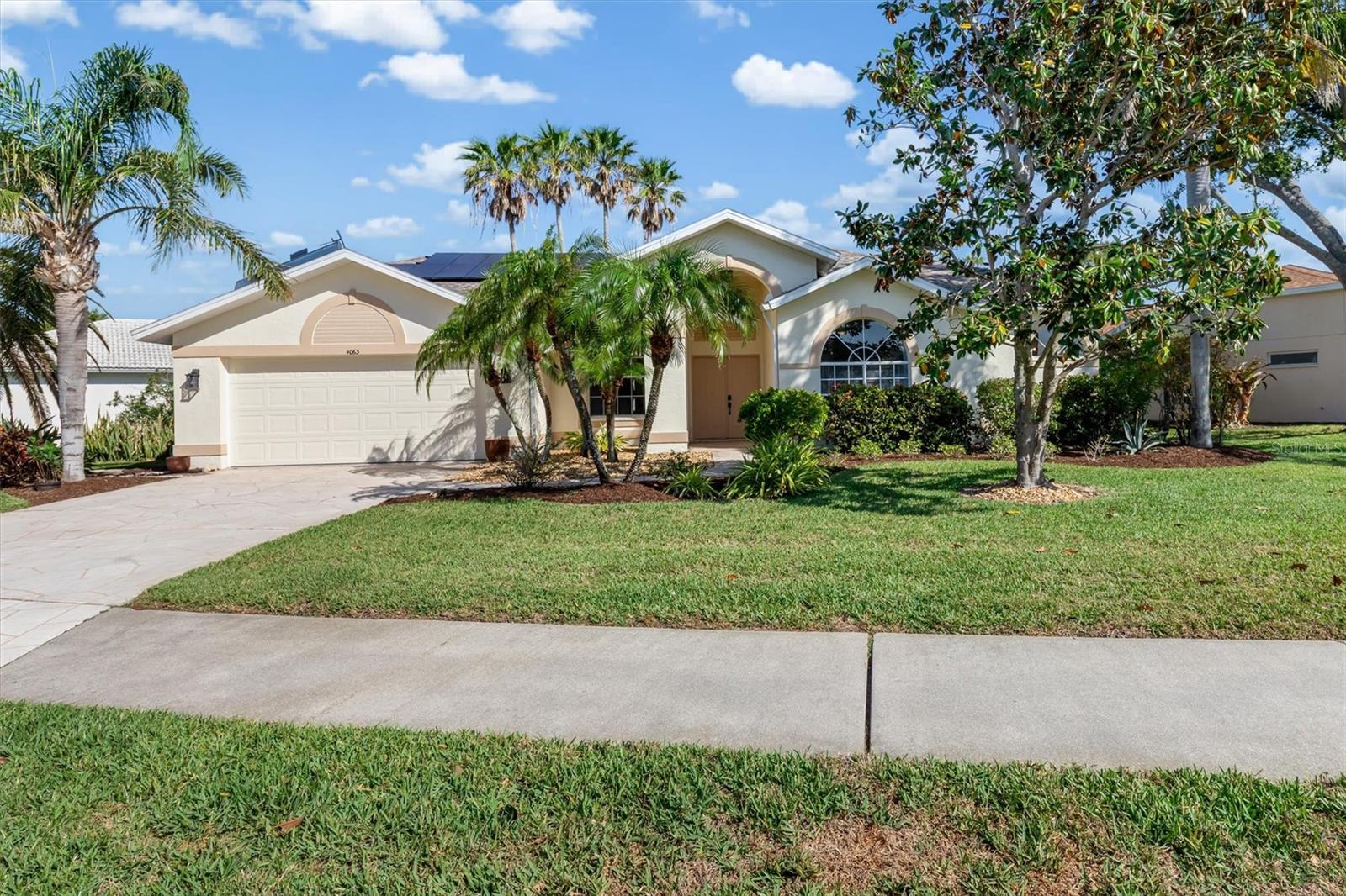 Welcome to this beautifully maintained 3-bedroom, 2-bathroom pool home with a 2-car garage, located in the highly sought-after gated community of Stoneybrook Estates at Palmer Ranch. This inviting home boasts a newer roof, a stamped concrete driveway and walkway, and exceptional curb appeal. Step inside to discover a bright and open layout featuring a formal living room with serene pool and long lake views, a separate dining area, and an open-concept kitchen complete with clean white cabinetry, granite countertops, white appliances, and a cozy breakfast nook. The family room offers direct access to the pool area and shares in the beautiful lake views, making it perfect for both relaxing and entertaining. The primary suite is a private retreat with walk-in closets, dual vanities, a garden tub, a walk-in shower, and a spacious area off of the primary bath perfect for an office, studio, or expanding the closet space. Additional highlights include a laundry room with garage access and recessed sliding doors from both the family room and primary suite opening onto a spacious lanai and pool area. Enjoy Florida living year-round with a new pool cage, stamped concrete lanai, and two covered terrace areas with ceiling fans—ideal for cool evenings and poolside gatherings. The solar panels provide energy-efficient heating for the pool and the home’s water system, helping to reduce utility costs. Residents of Stoneybrook Estates enjoy access to a community pool and the adjacent Stoneybrook Golf & Country Club, offering limited seasonal social and golf amenities. With tranquil lake views and a prime location, this home truly offers the best of Sarasota living.