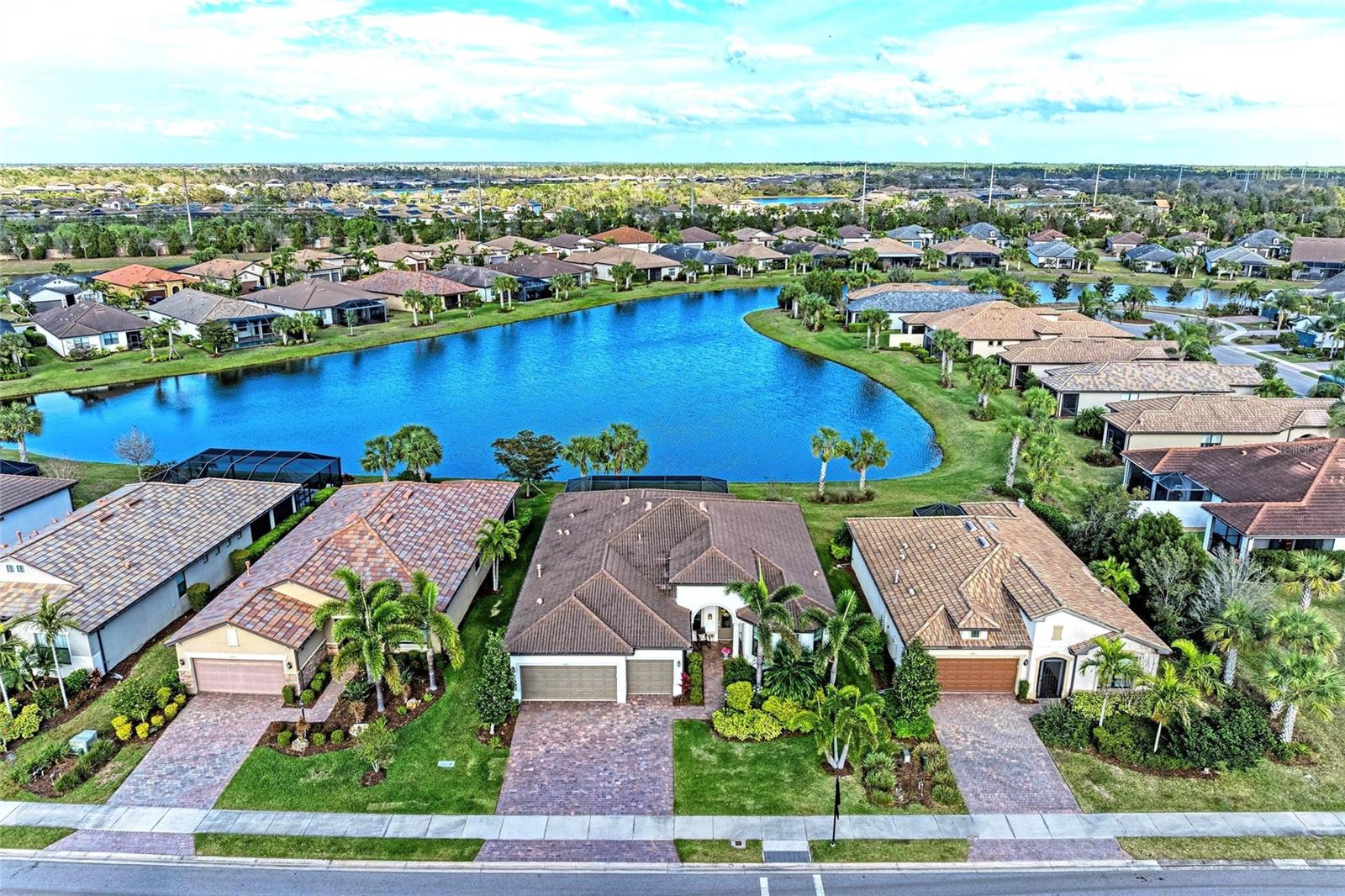 Experience true maintenance-free luxury living in this immaculate home, perfectly situated on a premium waterfront lot in the sought-after 55+ community of Del Webb. This residence has been meticulously upgraded with over $95,000 in designer features, offering elegance, comfort, and sophistication throughout.
The chef-inspired kitchen is a showstopper with quartz countertops, 42” upper cabinetry with under-cabinet lighting, a sleek glass backsplash, stainless steel appliances, range hood, and a large island overlooking the great room. Perfect for entertaining, the great room flows seamlessly to the extended lanai through a fully pocketing sliding glass door, blending indoor and outdoor living while capturing serene water views.
The spacious owner’s suite is a private retreat, featuring a tray ceiling with crown molding, engineered hardwood floors, and a spa-like en suite bath complete with a Roman walk-in shower, dual sinks, and a custom walk-in closet. A private den/office with French doors offers a peaceful workspace and a view of the front yard.
Built for peace of mind, this home includes hurricane impact glass windows throughout.
Del Webb offers a vibrant and active lifestyle with a stunning 28,000 sq. ft. Lakeside Clubhouse, heated resort-style pool and spa, on-site Sailfish Restaurant and outdoor bar, fire pit and grill area. Enjoy friendly competition on 6 tennis courts, 4 bocce courts, and 8 pickleball courts—or explore miles of walking and biking trails. With a dedicated lifestyle director and endless amenities, you’ll have everything you need to live your best Florida life.** Seller will pay the HOA dues through June 2026 and pay a $5000 credit towards closing costs.**