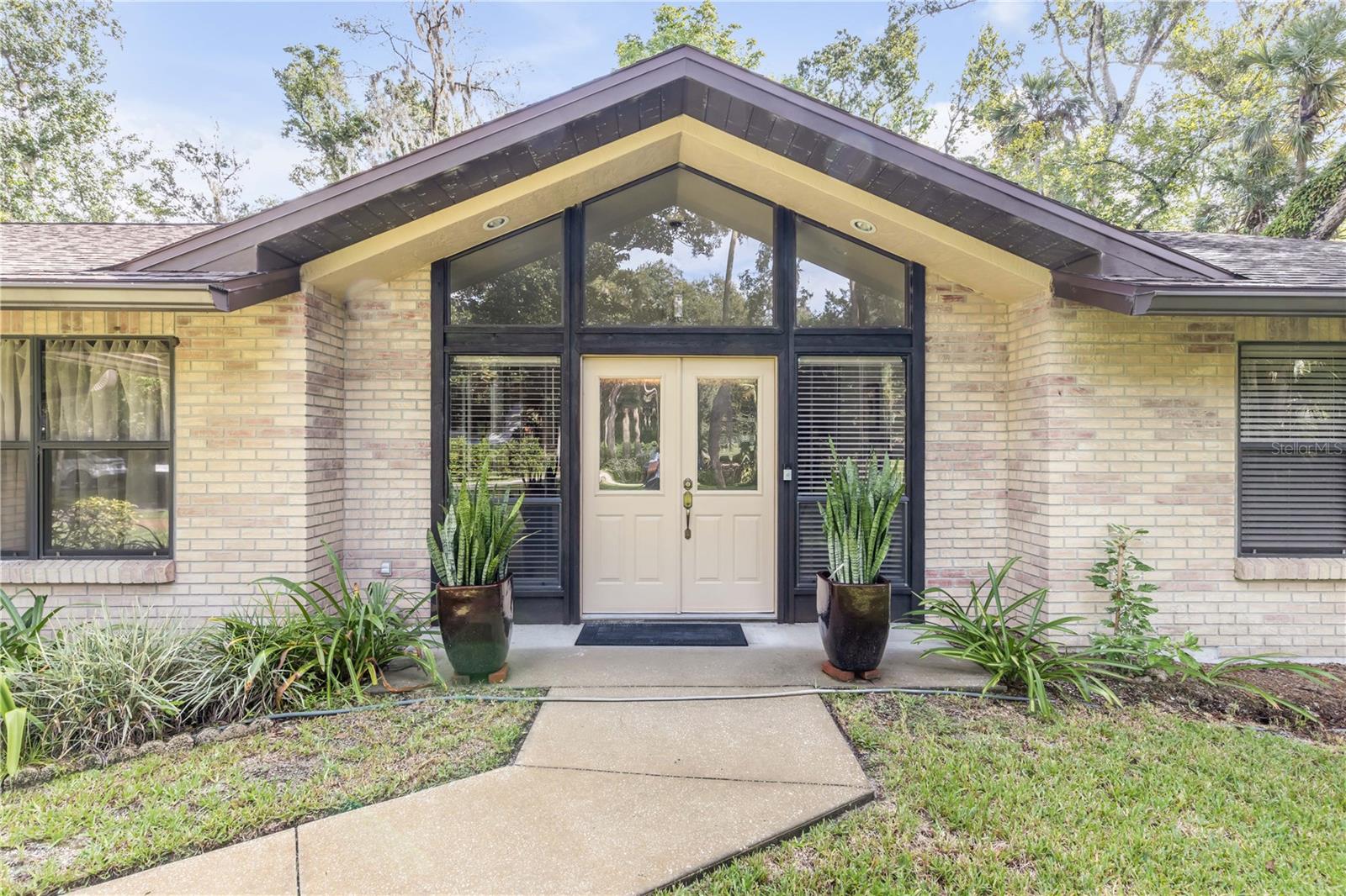STUNNING custom-built home on an ACRE of land in NSB! This 3-bedroom/ 2-bathroom home by Luxury builders sits on an acre of beautiful, lush green land on a quiet, well-kept street. The inviting floor plan includes an expansive living room with vaulted ceilings and a wood burning fireplace to entertain family and friends, and flex space off the living room that makes for a cozy den or perfect work-from-home office. The tasteful kitchen has granite countertops and is equipped with state-of-the-art Café appliances and a large walk-in pantry. The open dining area fits a large table and is perfect for hosting. The master suite is a sizable room that can fit heirloom furniture and a king size bed. The ensuite bathroom offers double sinks, a beautifully tiled shower and a walk-in closet. The two secondary bedrooms are spacious and share an updated bathroom with a newly tiled shower. The screened in back patio is a true gem with plenty of room for outdoor entertainment. A spacious deck off the patio is perfect for sun bathing or just enjoying the peace and quiet. The back yard has been fenced in for furry friends! This home features a two-car garage, a hook up for a whole-house generator, and a new garage door system with a remote controlled screen. BRING YOUR TOYS! NO HOA! This house has the best of both worlds- enjoy the quiet country feel while still centrally located in the heart of NSB, close to downtown Canal Street, Flagler Avenue, and the beaches. NO FLOODING!