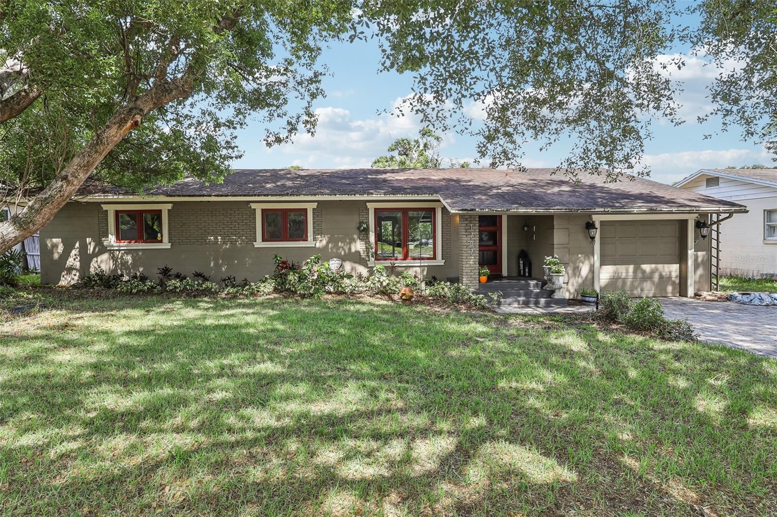 Located in the heart of Audubon Park, voted one of "Orlando's best neighborhoods," this lovely 3-bedroom, 2-bath house is situated on a quiet, tree-lined street, conveniently located close to everything. The open floorplan showcases the well-appointed chef's kitchen with custom cabinets, quartz countertops, two sinks (including a prep sink by the propane-burner stove), and double ovens. The original plank wood floors are in excellent condition and run throughout the home, including in the kitchen, the large living room, the bedrooms, the dining area, and the bonus office/den. The fully fenced backyard has a large paver patio and plenty of space for a pool. The garage features an expansive loft for tons of easy storage. All new windows installed in 2013, electrical was updated in 2012, AC compressor 2022. This centrally located neighborhood is just a 5-minute walk from the Audubon Park K-8 and all the shops and restaurants in the East End Market area. Additionally, Baldwin Park and Leu Gardens are a short bike ride away, and downtown Winter Park or Orlando are just a 10-minute drive. This solid mid-century charmer is priced to sell, so book your showing today!