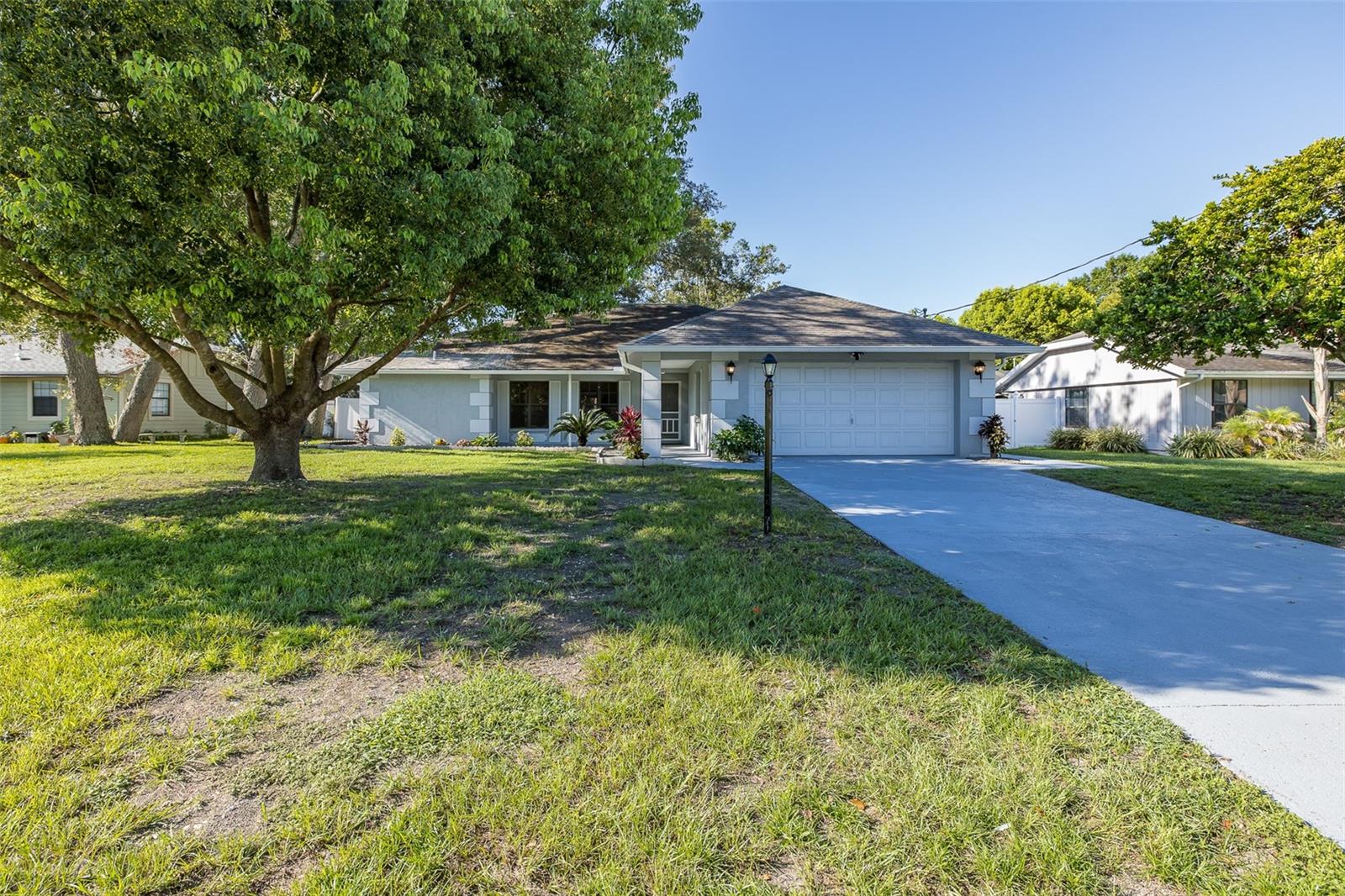 WELCOME HOME! This 3 bedroom 2 bath home with a big 2 car garage awaits your arrival. As soon as you drive up to the home you will notice the beautiful curb appeal. The minute you open the door you will be greeted with beautiful brand new luxury vinyl flooring, laced with 5 1/4 inch base boards. This home has it all, a gorgeous large family room with soaring ceilings, two brand new bathrooms (2023), large bedrooms, new ceiling fans and lighting, new stainless steel range and microwave, freshly painted, new landscaping, A/C (2023), new drain field with filter, and much much more!! The space of this home is incredible with the large screened in outdoor lanai (BOTH SLIDERS POCKET FULLY OPEN), and the front of the home is adorned with a charming front porch, WITH AN IRRIGATION SYSTEM AND RAIN GUTTERS. ALONG WITH A HUGE BACKYARD WITH PLENTY OF ROOM FOR A POOL. IMPECCABLY MAINTAINED AND EXCEPTIONALLY CLEAN. GREAT LOCATION IN A GREAT NEIGHBORHOOD!