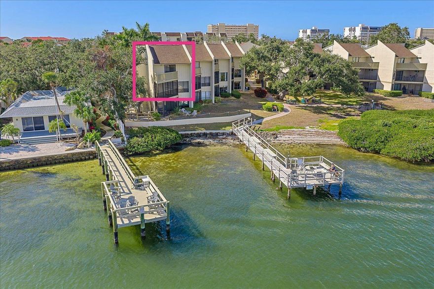 One or more photo(s) has been virtually staged. A true SIESTA KEY DIAMOND IN THE ROUGH, this rare waterfront residence offers what may be the most breathtaking Sarasota Bay intracoastal view in the entire Bay Oaks community—a view that feels endless, cinematic, and utterly transformative. Positioned directly on the water, this second-floor, two-level, two-bedroom, two-and-a-half-bath condo is a blank canvas waiting for someone with vision to unlock its full potential and create something truly extraordinary. Once reimagined, this home could be an absolute showstopper, whether as a deeply personal coastal retreat or a high-performing investment with weekly rentals permitted. The main living level features the living room, dining area, kitchen, in-unit laundry, and a convenient half bath for guests, while both generously sized bedrooms are located upstairs, each with private ensuite baths and large walk-in closets. One of the primary suites opens to a private, open-air covered balcony that faces directly over the bay—an intimate perch for morning coffee, sunrise reflections, and quiet moments where the water becomes part of daily life. Build-out renderings have been thoughtfully created to help visualize just how breathtaking this residence could become once updated. Bay Oaks itself enhances the lifestyle with a heated bayside pool, private fishing pier, waterfront picnic and BBQ areas, tennis and pickleball court, clubhouse with kitchen, pool table, and library, assigned covered parking, guest parking, covered bike storage, onsite management, and 24-hour video surveillance. Nestled on the bayside of world-famous Siesta Key, the community is surrounded by lush tropical landscaping, majestic live oaks, and swaying palms, with direct access to Sarasota Bay for kayaking, fishing, or simply soaking in the sunrise. The powdery white sands of America’s #1 Beach are just one mile away, and the free Siesta Key trolley stops directly outside the community. Upcoming community improvements—already paid for—include parking lot resurfacing, renovated carports following the 2026 season, and new pool furniture. This is an opportunity to fall in love not just with what this property is today, but with what it has the power to become—a waterfront home where vision meets view, and where the Florida lifestyle unfolds beautifully over the bay.