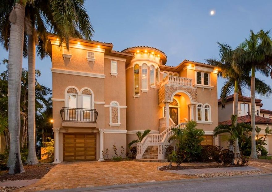 Step into the enchanting world of this stunning Mediterranean estate, where every corner reveals a tale waiting to be told. As you ascend in the elevator with its own elegant Chandelier - wander through the aesthetic living area on the third level, where a sink whispers the story of a sleeping beauty, and the mirror has the power to transform you into a real princess. Let's rewind a bit and explore what happens when a highly detailed, realistic setting encounters something too fantastical to believe. The moment you step through the doors, you'll notice that the Mediterranean elegance blends seamlessly with hand-painted art, inviting you to take your first step inside. The main level boasts a remarkably equipped kitchen with a Wolf gas stove, Sub Zero refrigerator, an oversized island surrounded by beige cabinetry and white stone granite countertops. A spacious living area with a welcoming fireplace is situated beside it. To the right, you'll discover a formal dining area inviting you to cuddle around the fireplace with your family. The travertine flooring throughout the home complements the style perfectly, leading you to a grand balcony with a primary outdoor kitchen. Cherry hardwood flooring runs throughout the second level, where you'll find a Full Slate $20,000 “9’ Olhausen Pool Table”, the master bedroom, a princess room on the opposite side, and, of course, a fully-equipped 10–Speaker Surround Sound Movie Theater with Star-Lit Ceiling and electric lay-flat lounge seating. All leading to a terrace with once again, awe-inspiring views. Downstairs, you'll discover a wine room, a social area, and an en-suite mother-in-law bedroom and bathroom setting, all leading to the Fresh Water Pool with Spa, which comes with a Waterfall and Fountain Water Feature - and a second outdoor kitchen by the wooden deck. (The 5th bedroom is currently used as an office on the main living level, it can be converted back into a bedroom.) The Whole House Sonos Sound System completes this home. Just a few more steps, and you'll arrive at the boat dock with a 16,000 Lb. Boat Lift - along with 2 Separate Sea-Doo Lifts attached to the Bay Dock. On your right you will see the Newly built outdoor Pergola with Lighted Bar overlooking the Bay. This home is truly a masterpiece. It's a blend of magical realism within the Mediterranean lifestyle that truly embodies the essence of home. I assure you that it won't disappoint.