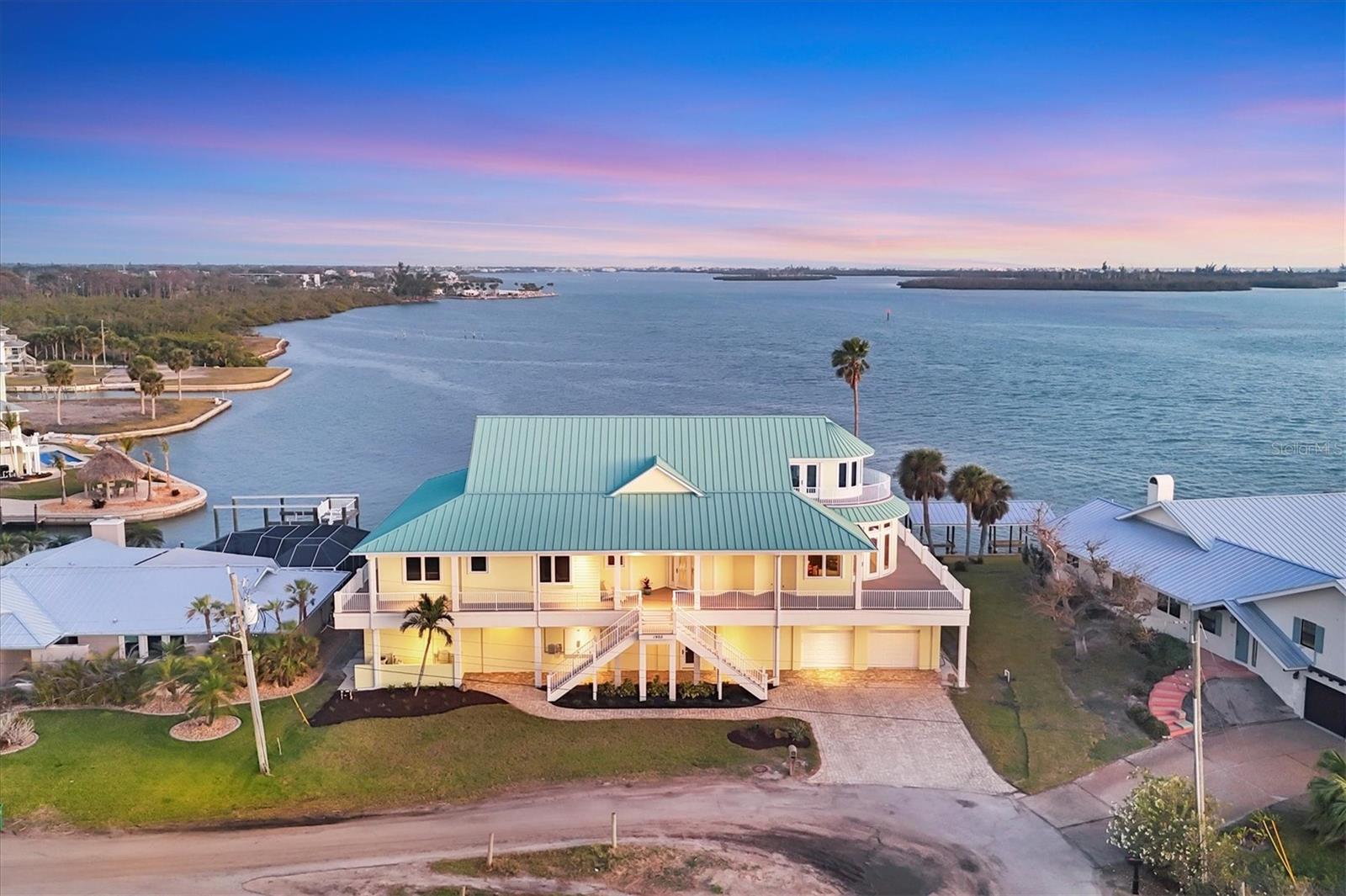 SUCH A UNIQUE PROPERTY! FOCUS on the details as this is NOT YOUR AVERAGE home with INCREDIBLE VIEWS! THE HISTORY of this property is just the beginning of the story! This 3rd generation family home provides the most AMAZING VIEWS ON THE INTERCOASTAL WATERWAY! Its unique location, lot placement and CUSTOM DESIGN offer MASSIVE WATER VIEWS from EVERY ROOM IN THIS HOME! Just wait until you SEE THE VIEWS FROM THE 3RD FLOOR with its RADIUS wall of WINDOWS! **Be sure to check out the 3-D Matterport walkthrough tour by clicking on the 'Tour 1' button at the top left of this MLS listing** This 4 BEDROOM/4.5 BATH home offers a BRAND NEW ROOF! 3 NEW HVAC's! Mostly NEWER APPLIANCES! NEW IRRIGATION PUMP fed from private well! NEW POOL PUMPS! SALT-WATER POOL/SPA with HEATER! NEW GARAGE DOORS and openers! New exterior doors! Custom built, SOLID CHERRY cabinetry with pull-outs throughout the CHEF'S KITCHEN! GAS FIREPLACE! ELEVATOR! ROUGHED-IN and WIRED for solar! Anything that was affected by the storm surge HAS BEEN REFTIFIED! No storm is a MATCH for this INCREDIBLY STRONG, WELL BUILT, BUNKER of a home! The history here is the FOUNDATION of its beauty! The original ground-level home was built with BRIDGE SPAN-CRETE ROOF TRUSSES as a HELECOPTER LANDING PAD! Those BRIDGE TRUSSES are supported by massive concrete pilings driven so deep that the bottom of the piles could not be located during the addition project in 2008! This once eye-sore, local hangout property, has NOW BEEN ESTABLISHED as THE CORNERSTONE PROPERTY in Grove City! City water and sewer! HURRICANE SHUTTERS/IMPACT GLASS to protect ALL glass openings! Wrap-around porch with AZEK decking and columns! BRAND NEW ROOF! CORAL WRAPPED GAS FIREPLACE! One-of-a-kind RADIUS kitchen COUNTERTOP to match the RADIUS GREATROOM and 3rd floor ROOFLINES! 6-burner GAS RANGE! SOLID CHERRY spiral stair case! CUSTOM MADE CHERRY interior doors and CUSTOM MILLED interior trim! NEWLY PAINTED exterior! This home has been EXTREMELY WELL MAINTAINED and CARED FOR and NO CORNERS have been cut in the process! Speaking of corners, check out the custom corner bead/no-door-casing trim as you attend your private viewing! Such ATTENTION-TO-DETAIL IS EVIDENT everywhere! There is too much to list, but here's a few details: Starting on the ground floor, the 8'-0" CANTELEEVER ROOF overhang patio off the back of the home is unique with these massive bridge roof trusses! The POOL/SPA placement is SPECIAL to this property's history, taking the place of what was once the boat basin that intruded underneath the home! ONLY THIS BUNKER OF A HOME can handle a SITE ENGINEERING FEAT as this! The storm surge rectification began at the ground floor by installing 48" DensShield Tile Backer to replace all compromised drywall. DenShield is a lightweight, water-resistant tile backer board with a built-in moisture barrier so that a drywall replacement process won't have to be done again! All the 1st floor amenities and ground level equipment has been completely replaced/remodeled, INCLUDING THE 1st floor POOL BATHROOM! FROM THE GROUND FLOOR remodel to the BRAND NEW ROOF, this home IS LIKE BRAND NEW all over again! Roughed-in for a CENTRAL VACUUM! Security alarm! Jetted tub! 3 hvac units installed FOR TOTAL COMFORT! NEW master shower tile walls! Surround sound inside and in the pool area! Outdoor kitchen electric and plumbing roughed in! New lanai and pool screening! As you can imagine, scheduling your private showing is a must with this beauty!