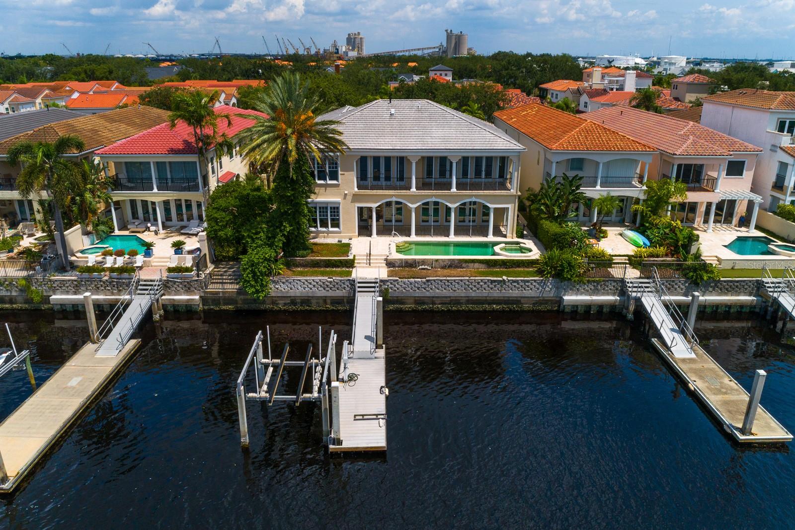 Waterfront living on a rare double lot in 24-hr gated Harbour Island, Downtown Tampa. This estate-size home awaits your TLC and features a grand 2-story foyer, sweeping staircase, and expansive living room with French doors opening to a covered balcony and stunning water views. Chef’s kitchen includes Viking gas range, Subzero fridge/freezer, warming drawers, and breakfast room. Full butler’s pantry connects to formal dining. First floor also offers a den w/ en-suite bath, large laundry room, and 2-car garage. Upstairs, the owner’s suite boasts private waterfront balcony, dual walk-in closets, spa bath, and adjacent wood-paneled office. All bedrooms have en-suite baths and walk-in closets. A 972 SF in-law suite includes private entrance, sitting room, kitchenette, and full bath. Whole-house gas generator, pool, and private dock with 10k lift. Walk to Riverwalk, Water Street, Amalie Arena, Bayshore, fine dining, and more. Easy access to I-275, Selmon Expwy, Tamp Int’l Airport, and Gulf beaches.