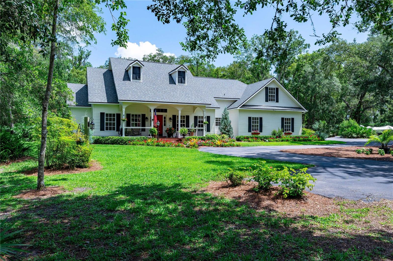 Welcome to your Dream Home. Situated just outside of San Antonio, minutes from Dade City, Wesley Chapel, and New Tampa, you’ll find the most meticulously cared-for home on almost 2 perfectly landscaped acres. With 5 bedrooms and 3 full bathrooms, a beautiful screened Lanai with heated pool, and a spacious front porch, this farmhouse-style custom house has everything you could ever want in a forever home. There’s a wrought iron fence entrance with automatic security gate and beautiful paved driveway that leads to a circle drive surrounded by professional landscaping, mature oak trees and vibrant flowers. You’re welcomed on the covered front porch that leads into a grand foyer where you can appreciate the open floor plan and over 10ft tall ceilings. On the main level there is a formal dining room, living room with built-in shelving and wood-burning fireplace, breakfast nook, and expansive kitchen with eat-in bar, huge walk-in pantry, Dacor double ovens with 6-burner gas range, high-end refrigerator, double sinks, and much more. You’ll find 2 bedrooms and a full bath on the main floor as well as the master suite. The master suite offers a sitting area with a gas fireplace, huge walk-in closet with built in drawers and shelving, and a 5-piece ensuite bathroom featuring a large garden tub, water closet, double sinks, and walk-in shower with double shower heads. There is a separate laundry room on the main floor with a window and laundry sink. Upstairs features two more large bedrooms with a full bathroom. One of the bedrooms offers a closet just outside the bedroom door. The other is perfect for a playroom or child’s bedroom. You will be pleasantly surprised that this wonderful home also offers an exercise room or flex space downstairs that was converted from one-half of the 2-car garage. It was enclosed and permitted by previous owners, and is the perfect extra room to work from home and get a workout in. The exterior of this home offers so many special features including a salt-water, heated pool with interchangeable lighting. The pool heater and pump were new in 2022. Paved sidewalks were added to the backyard, as well as a small fenced-in dog-run area just off the screened in Lanai. There is a two-story storage shed that was used as a shop, as well as a covered area for small equipment. The entire 1.87 acre property has been professionally landscaped and lovingly cared for. There’s even a cute wishing well, fire-pit and yard swing to top off this perfect set-up.