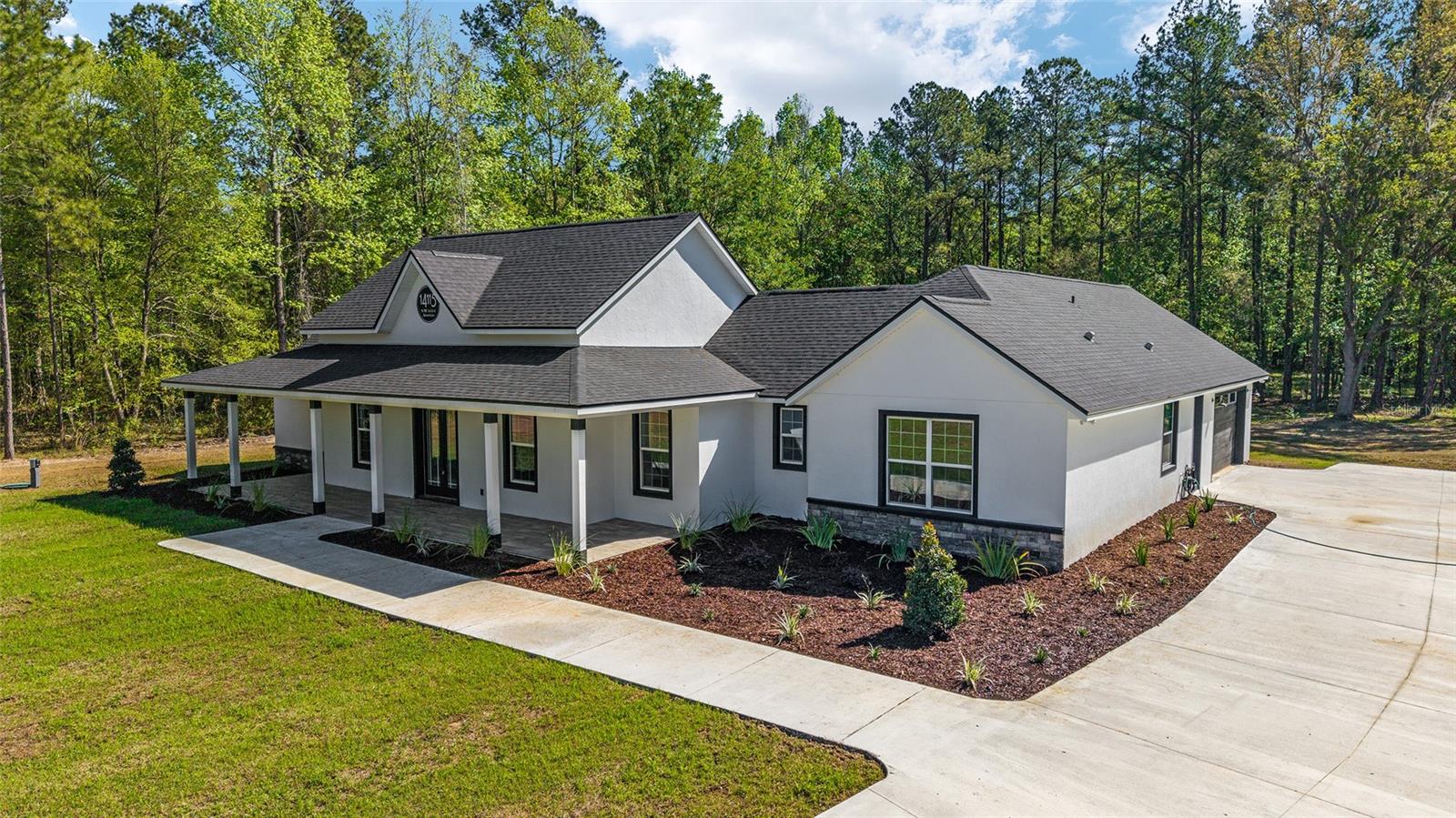 Welcome to this Builder's masterpiece, located in the tranquil Village At Hidden Lakes, a premier gated equestrian community known for its serene setting and abundant wildlife! This exquisite custom built 4-bedroom, 2.5 bath home is perfectly designed for both relaxation and entertaining, offering a spacious living environment and exceptional outdoor views. The seller, the builder himself, poured their heart and expertise into crafting this architectural gem, boasting unmatched quality and exquisite finishes! The black and white farmhouse design exudes a modern yet timeless elegance built on 2.4 acres of beautiful land! As you approach this beautiful property, a long custom concrete drive, lush landscaping and a charming front porch welcome you. Upon entering the front foyer, you'll immediately notice the beautiful wood-like luxury tile throughout the home and modern high-end finishes! As you enter, you'll be captivated by the expansive great room, complete with an electric fireplace that seamlessly opens to the grand kitchen. The kitchen is a chef's delight featuring an oversized kitchen island, quartz countertops, upgraded backsplash, brand new state-of-the-art appliances, modern farmhouse solid wood cabinets and high-end finishes that inspire culinary creativity! Additional dining options include a separate dining area as well as eating space at the island. Large windows flow seamlessly throughout the home allowing ample natural light complimenting the open floor plan and providing panoramic views of the beautifully landscaped property. The great room is open to the kitchen and features custom built-ins and fireplace, perfect for entertaining! The master suite is a luxurious retreat situated on one side of the home, boasting two exceptionally designed oversized walk-in closets with custom built-ins! An absolute must-see! The en-suite bathroom features dual vanities, luxury tile up to the ceiling, high end fixtures, a modern farmhouse tub and spacious custom glass enclosed walk-in shower. The opposite side of the home houses three additional oversized bedrooms, with walk-in closets and a spacious guest bathroom with dual sinks and glass enclosed shower-tub combo. In addition to the 4 bedrooms is an executive office featuring custom built-ins and large windows overlooking the beautiful front yard. Practical features include an oversized inside laundry room featuring wood cabinets, quartz countertops and plenty of storage, an oversized 3 car garage that features brand new epoxy flooring and an additional mudroom just off the back lanai. The outdoor living area is nothing short of spectacular, featuring an expansive lanai with luxury outdoor flooring, perfect for entertaining! Sip your morning coffee overlooking the peaceful, sprawling acreage or host a barbeque with family and friends! This space is ready for you to create your dream backyard oasis or Equestrian haven! There is plenty of space for grazing on some of the best soil/grass Marion County has to offer. Located less than 10 minutes from Williston, 20 minutes to Gainesville, 9 miles to the HITS showgrounds, 19 miles to the World Equestrian Center, and just 20 miles to Ocala, this property offers easy access to some of the best equestrian facilities in Marion County. Whether you're watching the breathtaking sunsets and views or observing the family of deer that frequent the property, This estate and community promises a life of peaceful enjoyment and equestrian excellence.