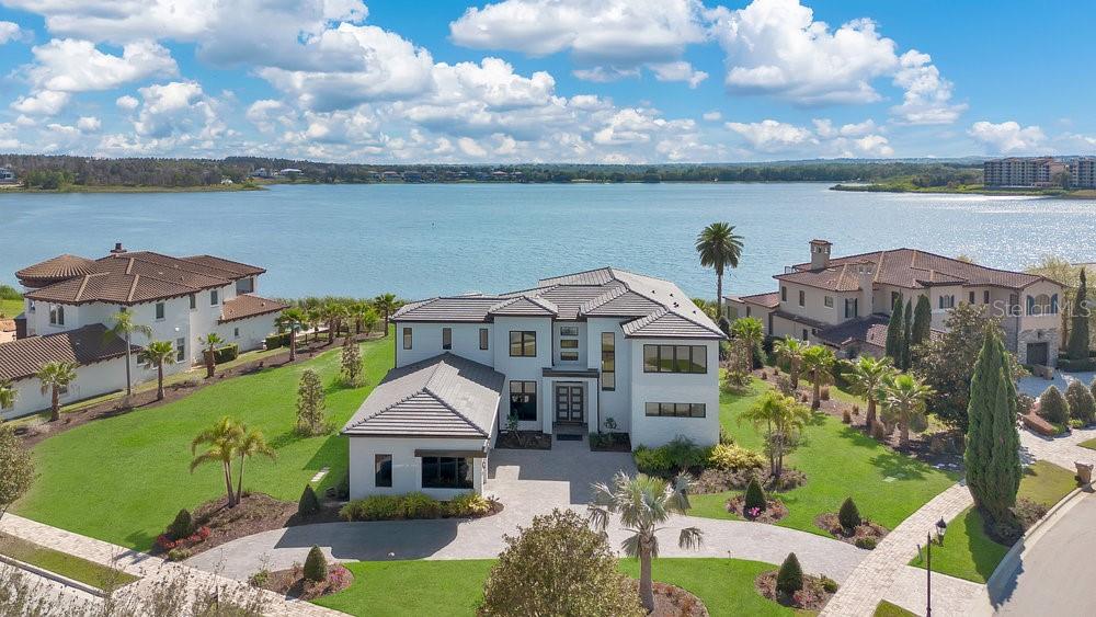 Welcome home to your newer lakefront estate totaling 8,500+ square feet on the desirable Lake Siena in the guard gated community of Bella Collina. Set on a prominent and rare one-acre lot, you will be greeted with a circular driveway, manicured landscaping, and a grand covered entrance with double entry doors. Upon entry you will be greeted with soaring high 24-foot ceilings, a chic chandelier, porcelain floors, large windows throughout flooding your home with natural light, and an instant “wow” factor with lake views from the formal living space. Chefs’ kitchen is fully equipped with professional grade JennAir stainless appliances including a 6-burner gas range with griddle, herringbone marble backsplash, a massive waterfall center island, designer pendant lighting, and a walk-in pantry that rivals other kitchens with a double oven, additional refrigerator, and its own sink. The family room is spacious with a tuxedo marble look accent wall and 10-foot sliding glass doors leading you to the outside lanai. The dining room is elegantly designed with a combination of wall accents, rectangular chandelier with branch lighting, and an adjacent butler’s pantry. The home boasts two primary suites (up and down). Both suites are large, with dual vanities, tub, separate shower, and walk-in closets. Secondary bedrooms are all spacious with their own bathrooms. There is an additional guest bedroom on the main level and a separate study. The outdoor living space was designed to enjoy the breathtaking panoramic lake views within the comfort and privacy of being home. Relax and enjoy captivating views within the serenity of the expansive outdoor living area which includes phantom motorized screens, summer kitchen, and a TV lounge area. The large salt-water heated pool includes a 360 spa combining water features and lighting making any setting awe inspiring. Your home is truly a one of kind property and a once in a lifetime opportunity to own an amazing lakefront estate that will be appreciated for many years to come. Bella Collina is one of Central Florida’s premier guard gated golf communities. The 75,000+ sq ft private country club offers amenities found in the best resorts including a 18-hole signature golf course, tennis, spa, pool, gym, and restaurants. Additionally, the community is close to Monteverde Academy and other major roads and highways linking Central Florida. Be prepared to enjoy the extraordinary lifestyle this property and the neighborhood offers to anyone that passes through its gates. Be sure to click on the virtual tour links!
<iframe width='853' height='480' src=https://my.matterport.com/show/?m=xaaK5i8gfgb&mls=1></iframe>