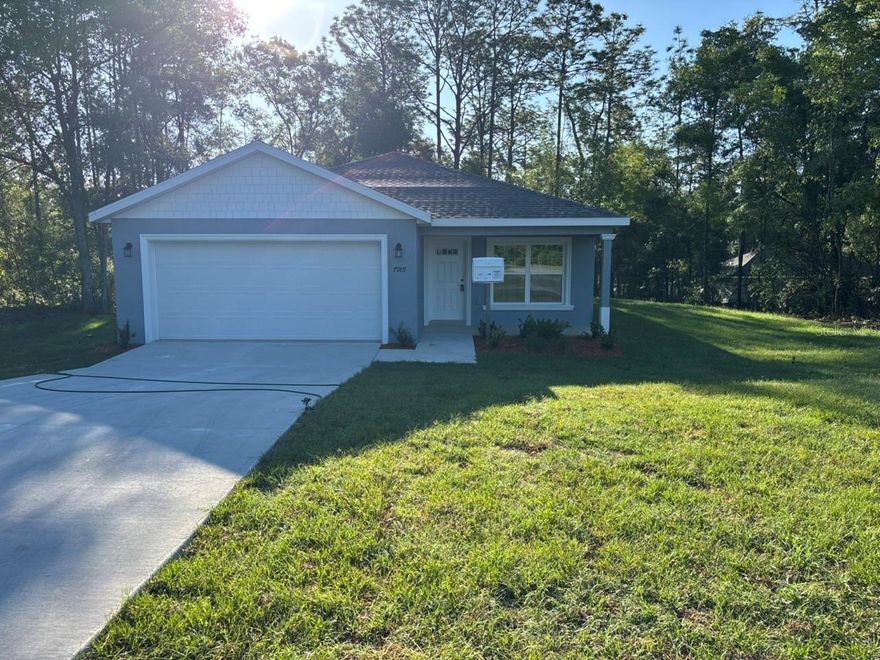 NEW CONSTRUCTION. MOVE-IN READY! Welcome to this beautiful New Anastasia Model in Citrus Springs, a 3-bedroom, 2-bathroom home with 1,409 square feet of living space and 2,057 total square feet. Built with quality concrete block construction, this home features a 30-year architectural shingle roof, energy-efficient double-pane windows, a 10-year structural warranty, and luxury vinyl plank flooring in the main living areas and bedrooms. The kitchen offers stainless steel appliances, custom white shaker cabinets with soft-close drawers, and granite countertops for a clean, modern look. The primary bedroom includes a tray ceiling with crown molding and a large walk-in closet, while the primary bathroom features a large shower and a double vanity with granite countertops. The second bathroom includes a tub with a shower and a single vanity with granite countertops. This home also includes multiple storage closets, a dedicated laundry room with washer and dryer hookups, covered front and rear porches, a shaker-finish gable, and an attached 2-car garage with an opener and remotes. Enjoy ownership freedom with no homeowners association fees and a high-and-dry location with no flood insurance required.