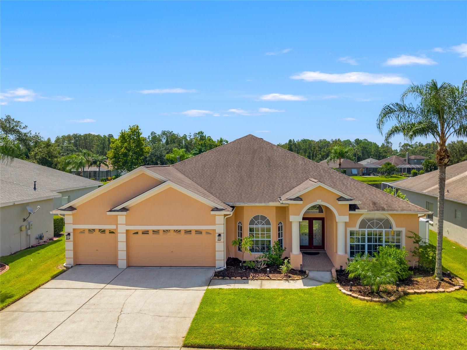 One or more photo(s) has been virtually staged. Welcome to 1406 Deerbourne Dr—an elegant and spacious 4-bedroom, 3-bath home located in the exclusive gated Manor Isle community of Meadow Pointe. This thoughtfully designed split floor plan offers privacy, functionality, and serene water views.
The owner’s suite is privately tucked away and features sliding glass doors that open to the lanai, along with a luxurious bath offering a walk-in shower, garden tub, dual vanities, and a separate water closet. On the opposite side of the home are three generously sized bedrooms—one with its own private bath, and two that share a full hall bath, perfect for guests or a growing household.
Enjoy multiple living spaces, including a formal living room and dining room, plus a spacious family room with a wood-burning fireplace. The heart of the home is the open-concept kitchen, featuring granite countertops, stainless steel appliances, a center island, breakfast bar, and cozy eat-in nook—all overlooking the family room and outdoor space.
Step outside to a large screened-in lanai with peaceful water views, ideal for morning coffee or evening relaxation. High ceilings throughout add to the home’s bright, open feel. Additional features include a laundry room and a 3-car garage for added storage and convenience.
Located a short distance to top-rated schools, AdventHealth Hospital, Baycare Hospital, Wiregrass Mall, Tampa Premium Outlets, I-75 & I-275, restaurants, grocery stores and more—this home offers the perfect blend of comfort, convenience, and tranquility.
Meadow Pointe 2 has a fantastic club house with a pool, playground, gym, and so much more.