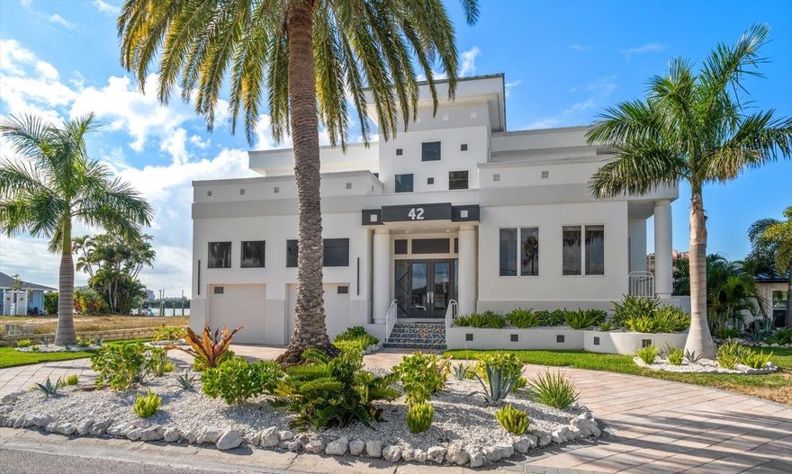 Welcome to a world of unparalleled luxury and coastal elegance. Nestled within the waterfront community of Island Estates, this remarkable home embodies the epitome of modern beach living, offering a rare opportunity to own a piece of paradise. 42 Midway offers a very popular feature set: Location, boat dock, direct Gulf access, pool, privacy, exclusivity, and of course, the luxurious active outdoor lifestyle that comes with it all. This exquisite 4 bedroom, 3.5 bathroom residence spans 4944 square feet of beautifully designed living space. Revel in the breathtaking panoramic views of the glistening waters from nearly every room, creating an ambiance of serenity and grandeur. The open floor plan layout, designed with the finest attention to detail, offers an ideal setting for both lavish entertaining and intimate family living. The gourmet chef's kitchen features top-of-the-line appliances, sleek custom cabinetry, and luxurious finishes, making it a focal point of the home. Meanwhile, the expansive living areas are adorned with soaring ceilings and walls of glass, inviting an abundance of natural light and picturesque views indoors. Step outside to your own private retreat, featuring a spacious patio with tropical landscaping, a state-of-the-art outdoor kitchen, pool and hot tub and a private dock with a boat lift, offering direct access to the open waters. This waterfront home represents a once-in-a-lifetime opportunity to indulge in the ultimate luxury lifestyle, combining the allure of coastal living with the finest amenities and unmatched natural beauty.