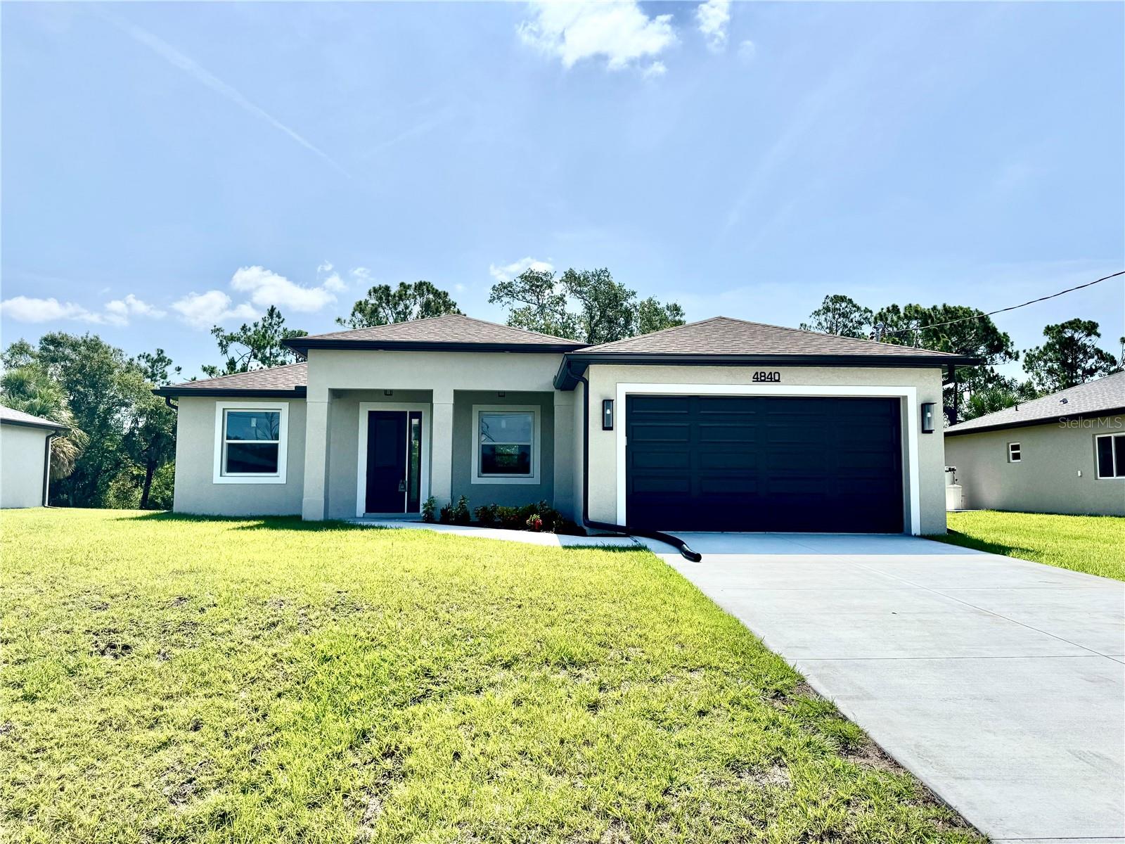 Brand-new modern luxury home featuring 3 bedrooms, 2 bathrooms, and a fully enclosed office (optional 4th BR) with soaring 9.4' ceilings. Located in a prime area with no HOA and outside the flood zone. Interior showcases Spanish porcelain tile throughout, impact-resistant windows and doors, and an open-concept living space with large double doors leading to a tiled lanai overlooking a peaceful freshwater canal. The chef’s kitchen includes quartz countertops, 42" soft-close cabinets, under/over cabinet lighting, stainless steel appliances, range hood, and stylish backsplash. The primary suite offers a walk-in closet and spa-like en-suite bathroom with a double vanity, linen closet, and walk-in shower with a bench. Both bathrooms have full-length tiled shower walls. MOEN plumbing fixtures are featured throughout the entire home for consistent quality and style. Additional highlights: Interior laundry room with sink, seamless gutters, quartz windowsills, and designer lighting throughout.