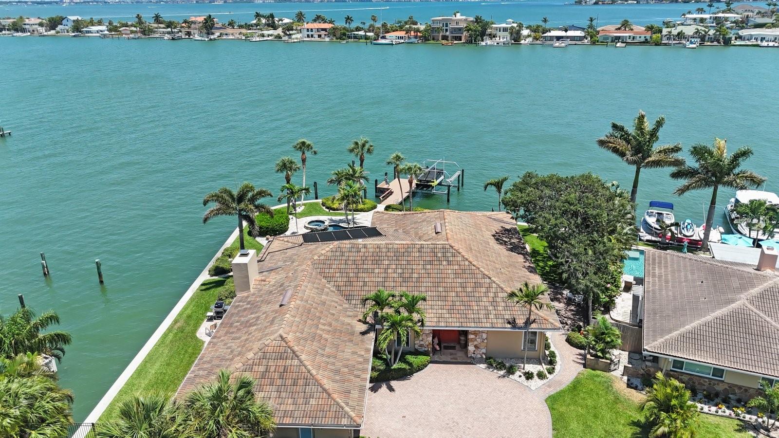 Welcome to your Bahia Shores waterfront home located on an oversized Corner lot and private Cul-de-sac. This tiled roof home has a gross square footage of 3915 ft and 2551 sq ft of living space. Your new home has 3 bedrooms 3 baths and 25x27 sf 2+ car garage with 12 floor to ceiling cabinets, sink, hi-impact garage door and windows. Enjoy the beautiful waterfront views of Boca Ciega Bay with 250 Feet of seawall reconstructed in 2010. There is a boat slip with 17k lift and a 50ft wet slip with 50-amp shore power. Enter through the front door and be awed by the water views which can be seen from just about every room in the house. The home was built in 1970 and has been very well maintained and upgraded. Plantation shutters, ceramic tiles and hurricane rated windows and sliders throughout the house. The combined kitchen and family room make the space 43x28 sq ft. with a wood burning fireplace. The Kitchen has a sub-zero refrigerator with custom front matching the cabinets. The stainless-steel appliances are Kitchen-Aide which include Dishwasher, Range, microwave and an under counter or stand-alone Ice Maker located in the bar. The counter tops are granite, an Island with storage & electric for easy meal preps and a snack-bar. The Laundry room has Washer/Dryer, sink and an 80 gal. stainless steel water heater in the large storage closet. The combined Living room/Dining room measure approx. 26x20. There is a floor to ceiling hi impact glass panel and triple pocket sliding doors allowing full water views. The primary bedroom has a bay window, double slider, his and hers walk in closets and the bath has huge walk-in shower with bench, dual vanities and a powder room. The upgraded guest Bath room sits between two guest rooms and has tub and shower, 2nd guest bath is located in the hallway between kitchen and dining room . The 2nd guest room has a large closet for clothing and storage. The patio is covered by a tongue and groove ceiling, large TV on the wall, motorized multi-zoned screens that enclose the entire space. Teak table with chairs and coffee table can stay for convenience of seller. Cose to beaches, restaurants, shopping, grocers. medical offices, hospitals, downtown St Petersburg and museums. This is a must-see home, perfect for avid boaters and entertaining or hosting overnight guests. Book an appointment to see for yourself. Flood Insurance is transferrable. Room sizes are approximate only, buyer to use due diligence.