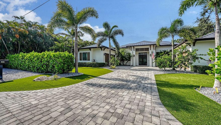 Located West of Trail near the historic Field Club, this stunning residence is a refined interpretation of British West Indies architecture,
 offering over 4,000 square feet of thoughtfully designed single-level living. Set on an estate lot, the home blends timeless coastal elegance with exceptional craftsmanship and seamless indoor–outdoor flow. A dramatic great room welcomes you with vaulted wood ceilings, fireplace, and expansive pocketing sliders that frame views of the lushly landscaped pool and spa. The open-concept design flows effortlessly into the chef’s kitchen, appointed with premium Thermador and Wolf appliances, custom solid-wood cabinetry, quartz surfaces, and an oversized island—perfectly complemented by a separate dining area and custom dry bar with wine refrigeration. Designed for both privacy and versatility, the residence features four en-suite bedrooms, office, and a spacious TV lounge or bonus room that opens directly to the outdoor living areas. The private primary suite is a serene retreat with a vaulted wood ceiling, dual walk-in closets, and direct access to the covered lanai. Its spa-inspired bath showcases dual vanities, a soaking tub, and an expansive glass-enclosed shower. Outdoor living is a true centerpiece, with a generous travertine lanai, fully equipped outdoor kitchen, dining verandah, and a large gas- and electric-heated saltwater pool and spa with waterfall—ideal for entertaining or quiet relaxation amid tropical landscaping and architectural lighting. Additional highlights include hurricane-rated impact windows and doors, a whole-house generator, brand new metal roof, dual on-demand water heaters, an expansive paver motor court, low maintenance & fenced yard, and a rare four-car garage configuration, including an owner’s garage with EV outlet and climate control. Ideally located minutes from Siesta Key, Southside Village, Sarasota Bay, and downtown Sarasota, this exceptional home offers privacy, design integrity, and proximity to the best of the Sarasota lifestyle