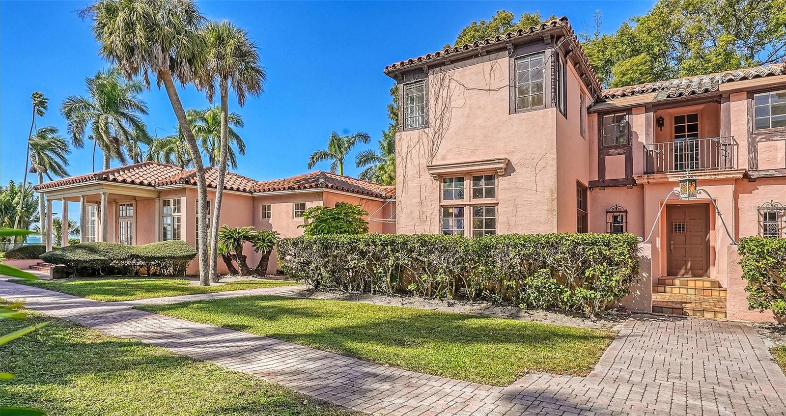 Sited on 1.1 acres of direct Bay Front where Sarasota Bay is its widest provides shockingly beautiful open water views along with priceless sunsets for this classic two-story Mediterranean Revival residence. The gated estate is set back from the point where Bay Shore Road curves at Ainsley Place and is called The Etowah named for the Etowah River in north Georgia. The 5,812 sq. ft home will require a major renovation to the original structure and the large extension added to the west of the home in 1992 by local architect Frank Folsom Smith. The historic portion of the home still has an amalgam of well-proportioned rooms, its original light sconces, wood floors, and beautiful arch details. The entry features a vaulted ceiling which leads to the living room centered on a beautiful fireplace as a focal point. The sunroom is surrounded in with windows of original circus glass. The dining room is on scale for entertaining. The adjacent kitchen is privy to an old fashioned back staircase leading to the second level. The 2nd level features the original owner’s bedroom claiming front and center position onto the view with 3 other bedrooms on this level. In the added wing, an oversized Great Room, an auxiliary kitchen and large owner’s quarters with a walk-in closet and spacious bath provide open water views. An original garage joins the home with separate 2nd level guest quarters.. The covered boathouse is also historically designated. The home has been unoccupied for a considerable period of time. A serious renovation is required. The list price is considered to represent land value.