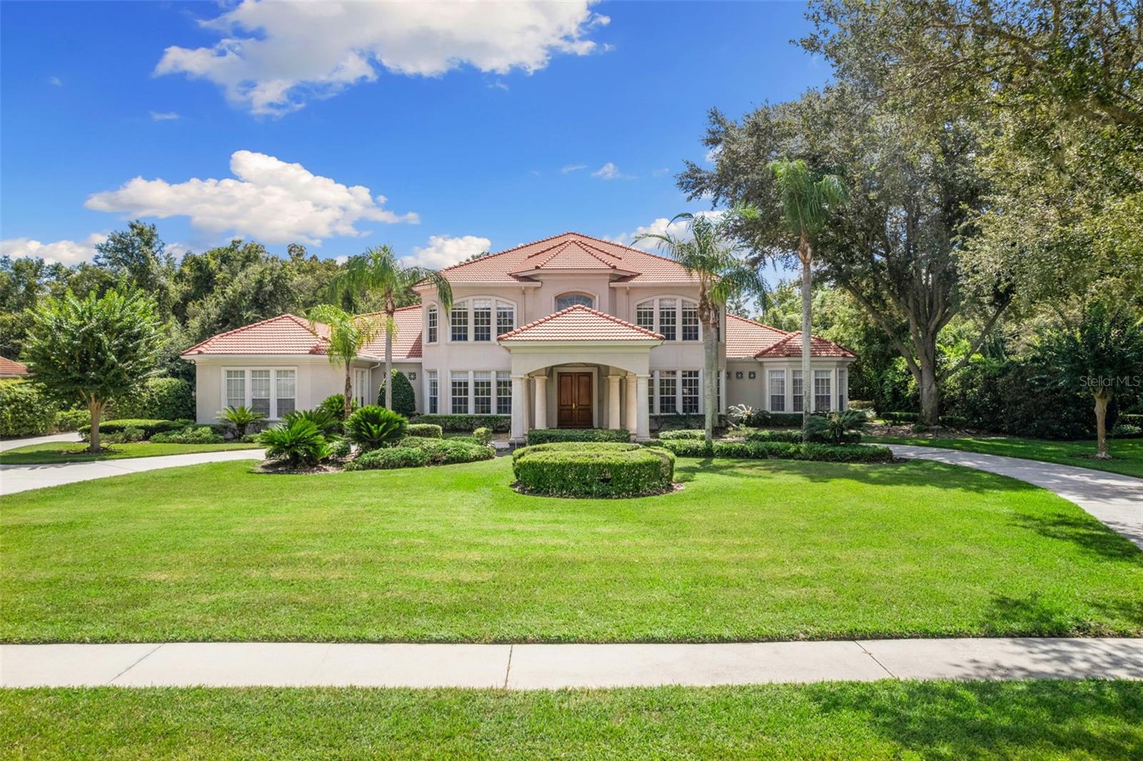 Welcome to this luxurious 6 bedroom/7 bath grand estate built by Jay Fechtel in the prestigious double-gated enclave of Heritage Oaks, where timeless elegance meets modern convenience. The circular drive is flanked by meticulously manicured landscaping, swaying palms and majestic oaks. Step inside to the grand two-story foyer, illuminated by a state-of-the-art chandelier, setting the stage for the opulence that lies ahead. The formal living room, with its floor-to-ceiling windows, invites an abundance of natural light, creating an open and airy atmosphere. Entertain in style in the expansive formal dining room, complete with a stunning chandelier that adds an extra touch of sophistication to your gatherings. The open floor plan seamlessly connects the main living areas, featuring soaring ceilings and an array of windows and sliders that frame serene views of the secluded conservation area in the backyard. The chef’s kitchen is a true masterpiece with premium stainless steel-appliances, including a gas cook-top with flat-top and griddle, granite countertops and a breakfast bar. This spacious kitchen also offers potential for a secondary kitchen, already plumbed with water & gas. For those who work from home, the presidential study offers a sophisticated retreat, featuring wood casings, custom built-ins and an exquisite crystal chandelier, providing both functionality and elegance in a professional space.The luxurious master suite is a private oasis offering dual walk-in closets with custom built-ins, a spa-like ensuite bath featuring double vanities, a private water closet with bidet,an Aquatic 2-person hydrotherapy air and whirlpool combination bathtub and a lavish dual shower equipped with the Kohler DTV system. Enjoy the ultimate shower experience with overhead rain showers, body sprays, steam shower, ambient lighting, and built-in speakers. An additional well-appointed bedroom with ensuite and a pool bath ensure comfort and privacy for family and guests alike. Upstairs, the home continues to impress with four additional bedrooms, all with ensuite baths, and a state-of-the art 8 seat theatre room promising an unparalleled cinematic experience without ever leaving home. Step outside to the impressive outdoor living space, where a large covered patio and backyard space await. The outdoor kitchen, outfitted with high-end Alfresco and Fire Magic appliances and granite countertops, is perfect for alfresco dining. The expansive pool enclosure includes a large balcony with a wet bar, ideal for entertaining. Custom finishes and thoughtful details throughout, including an elevator for added convenience, elevate this estate to a class of its own. This family home offers every modern convenience, from the luxurious amenities to its perfect location. Residents of Hunter’s Green enjoy access to the country club’s golf course, tennis courts, swimming, fitness center, and neighborhood parks. You'll be just a short drive from I-75, top-rated public schools, and nearby Advent, Moffit, and VA hospitals. Plus, the area is home to Flatwoods Park, Wiregrass Mall, Tampa Premium Outlets, and The Village at Hunter’s Lake, making errands, dining, and entertainment incredibly convenient. This home is not just a place to live, but a lifestyle.