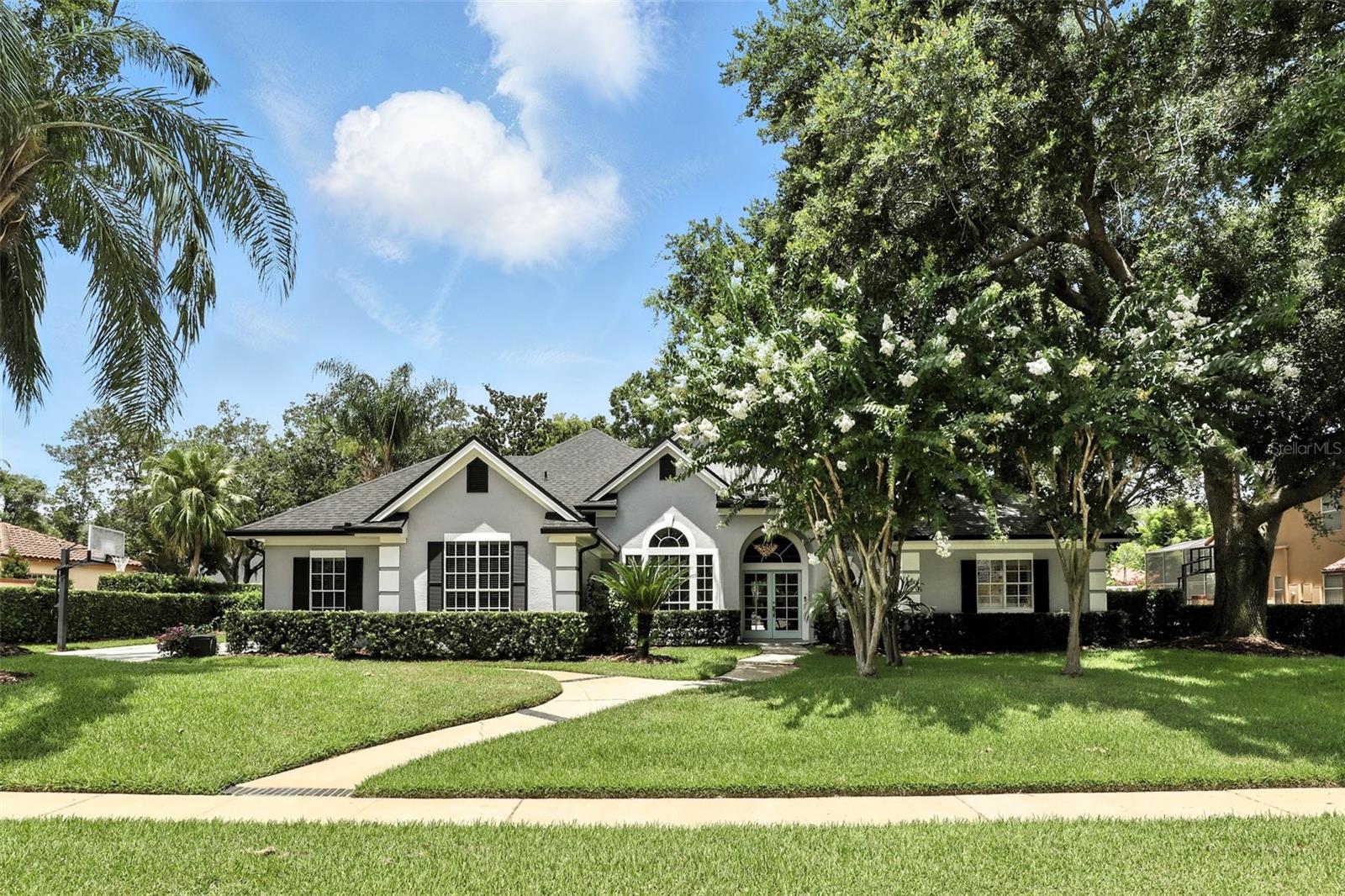 Discover the exceptional Winter Park neighborhood of Bear Gully Pointe, a gated community rich with amenities and anchored by a 137-acre spring-fed lake. This meticulously crafted home sits in a private cul-de-sac and stretches over almost ½ acre with mature landscaping and includes a secluded, fenced back yard. Function is paramount with a three-way split floorplan with four bedrooms and 4.5 baths and over 3,400 square feet of mostly first-floor living. The upstairs enjoys a flexible bonus room and bath that can suit any buyer’s needs. Rich hardwood flooring throughout the main living areas and primary bedroom add warmth and beauty to this home. An open kitchen with 42-inch custom wood detailed cabinets, bar seating and center island adorned with granite countertops and natural gas cooking that would fulfill any chef's dream. The kitchen opens to the family room which has a built-in entertainment center and gas fireplace. The family and living rooms feature seamless glass doors to pool. The pool is shaded by an expansive screened enclosure and covered porch is generous to entertain guests or just relax and take in Florida sunshine. Lots of surrounding green space to roam or expand the home. Other features of the home include a three-car side entry garage with additional parking area, newer roof and skylights 2022, air-conditioning unit and blower by Frank Gay 2023, replumbed, freshly painted inside and out, updated floors in bedrooms and some appliances updated. An established community includes sidewalks, tennis courts, playground and lake to make outdoor activities a breeze. Easy access to SR 417, Winter Park, UCF, downtown Orlando, Orlando International and Sanford airports, Rollins and Trinity Prep. An incredible opportunity in Winter Park.