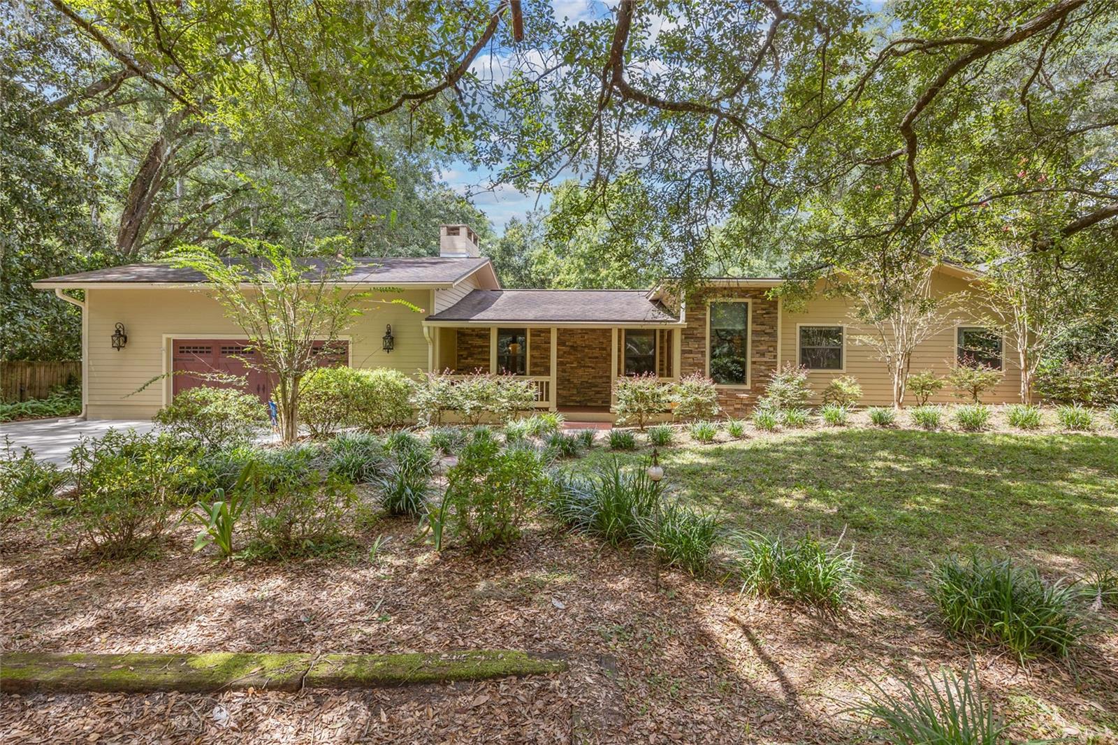 One or more photo(s) has been virtually staged. Welcome to intergenerational living at its finest! This beautiful house sits on 1.03 acres and offers 2,678 sqft of living space with 4 bedrooms, 3 full bathrooms, a bonus room, and an attached oversized 2 car garage. Just behind the main house sits an 840 sqft guest house built in 2017 with a living room, kitchen, bedroom, small office, full bath and half bath. As you approach the main home, you will enjoy the low maintenance front yard with charming curb appeal, the shade of mature trees, ample parking for guests on the driveway and parking pads, and the inviting front porch. Step through the front door into the foyer which leads to the expansive living room and dining area. You’ll appreciate the gas fireplace in the living room on those cooler winter days, and the easy-care tile flooring throughout the entire home. The large kitchen is located in the heart of the home and features quartz counters, solid wood cabinets offering tons of storage, stainless steel appliances, a pantry, and a breakfast bar - all of which make cooking and hosting gatherings with friends and family a breeze. The primary suite is located behind the kitchen on the right side of the home. Here you will find a sizable bedroom, two large walk-in closets, a sliding door which takes you outside to a small patio, and an ensuite bathroom featuring a tiled walk-in shower and a double vanity. Two secondary bedrooms are situated on the right side of the home off the dining room and they share a large hall bath with a double vanity and tub-shower combo. Located behind the kitchen to the left is a bonus room/office/second living room which connects to a second primary bedroom with a walk in closet and ensuite bathroom with tub-shower combo and single vanity. This suite is accessible from inside the home and also has a door leading to its own outdoor patio, giving it a private entrance at the back of the home. You have plenty of space for your vehicles and tools as the property comes with an attached oversized 2 car garage and a shed. The solar panels installed in 2018 on the main house help keep your electric bill to a minimum. The indoor laundry room is conveniently located at the front of the home near the garage. The 840 sqft guest house was built in 2017 and is accessible by a sidewalk from the driveway or along a walkway from the main house. As you enter the guest house you’ll appreciate the light and bright open floorplan with the kitchen to your left and the living room on the right, with tile flooring throughout the entire home. The kitchen has granite countertops, wood cabinets, and stainless steel appliances. The living room has French doors that open to your screened in porch overlooking the expansive back yard. This lovely small home also features a bedroom with walk in closet and ensuite bathroom with tiled walk-in shower and single vanity. Down the hall from the living room you’ll find a small office as well as a half bathroom for guests. With over an acre to yourself, enjoy peace and quiet or use your imaginations and add a pool, grow a garden, host endless bbqs or create your very own mini golf course. Possibilities have no end! This property is in a prime location in the neighborhood of Sunningdale in Gainesville with NO HOA, close to HCA North Florida Hospital and I-75, and just a short drive to UF, UF Health Shands, Town of Tioga, Celebration Pointe, and Santa Fe College. Stop by and discover the beauty of this home and all it has to offer!