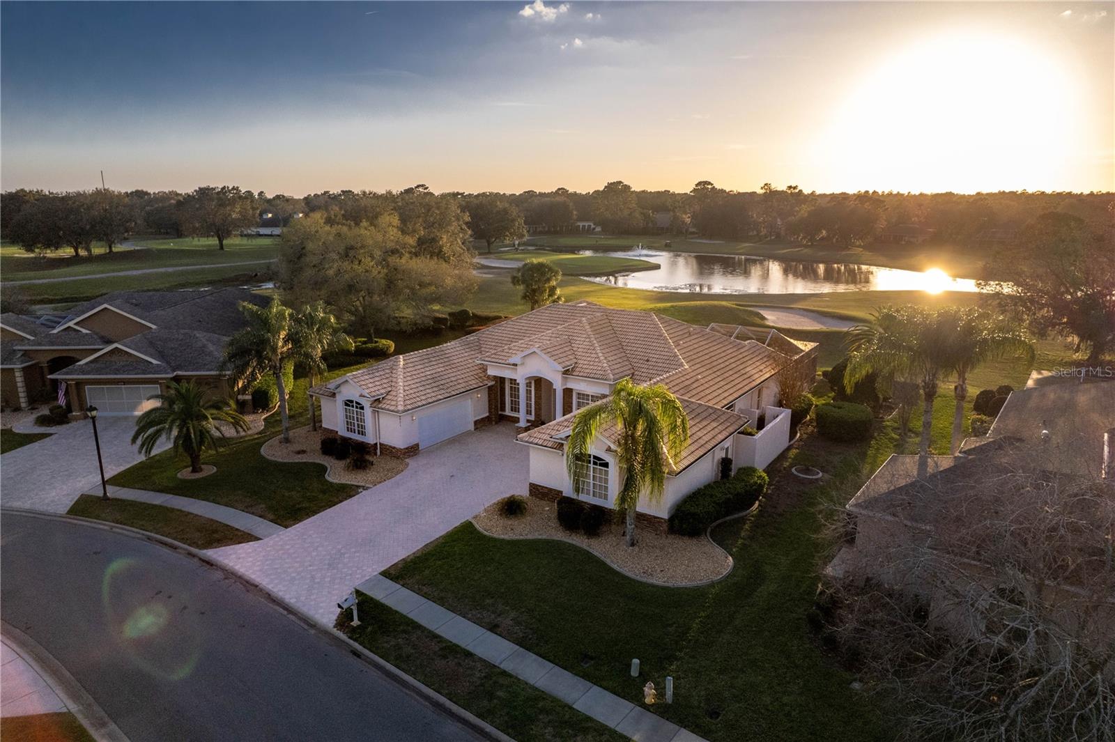 Tucked within the prestigious guard-gated Silverthorn Golf & Country Club community, this exquisite 4-bedroom, 4-bathroom estate blends timeless elegance, thoughtful craftsmanship, and serene golf course living. Meticulously maintained and tastefully upgraded, the home showcases soaring 12-foot ceilings, rich hardwood flooring, and over 70 custom cabinets and drawers thoughtfully placed throughout for optimal storage. The striking exterior features a wide pavered driveway, manicured landscaping, a Mediterranean-style tile roof, and eye-catching stone accents. Twin oversized 2-car garages with newer epoxy-coated floors are discreetly positioned on either side, offering ample room for vehicles, hobbies, or storage. A grand covered entry opens into a welcoming foyer flanked by a formal dining room on one side and a sophisticated office or den on the other, all grounded by elegant hardwood flooring. The formal living room centers around a stone gas fireplace and opens through sliding glass doors to a breathtaking lanai overlooking the 18th hole. Just beyond, the sunlit breakfast nook is surrounded by windows that maximize natural light and showcase the tranquil view. The heart of the home—a spectacular kitchen—is both functional and beautifully appointed with granite countertops and backsplash, a large center island with built-in wine racks and cabinetry, double convection wall ovens, a cooktop, a breakfast bar with double sink, and an exceptional volume of custom wood cabinetry beneath soaring ceilings. The kitchen flows seamlessly into a spacious family room featuring a dramatic triple trey ceiling, detailed crown molding, and another triple sliding door bringing the outdoors in. The luxurious primary suite serves as a peaceful retreat with tray ceilings, crown molding, private lanai access, a full wall of windows offering sweeping golf course views, and dual walk-in closets. The spa-like ensuite bathroom offers a jacuzzi garden tub with views of a private courtyard (with water and electric hookups), a large walk-in shower, dual vanities, a seated vanity space, and a private water closet. A generously sized second bedroom (20x13) is ideal as an in-law or guest suite and features private access to a serene patio with golf course views. The screened lanai is a showstopper, boasting a heated pool and spa with an in-floor cleaning system, brick paver decking, and a covered outdoor kitchen area with sink and refrigerator. Additional upgrades include hurricane-rated windows, a central vacuum system, a security system, commercial-grade water softener, 2019 Rheem dual-zone HVAC systems with NP2 filters and UV light, a newer Rheem Prestige water heater, exterior paint (2017), and an irrigation well for landscape maintenance. Residents of Silverthorn enjoy resort-style amenities including an Olympic-sized pool, tennis, pickleball, and basketball courts, a fitness center, library, activity rooms, and a stately clubhouse with a restaurant, bar, ballrooms, and golf pro shop. Just 2.5 miles from the Suncoast Parkway, this location offers a direct and convenient commute to Tampa. Nearby attractions include Weeki Wachee Springs State Park (9.5 miles), Hernando Beach (14 miles), and the Nature Coast Botanical Gardens (6 miles), making this home a rare blend of luxury, lifestyle, and location.
