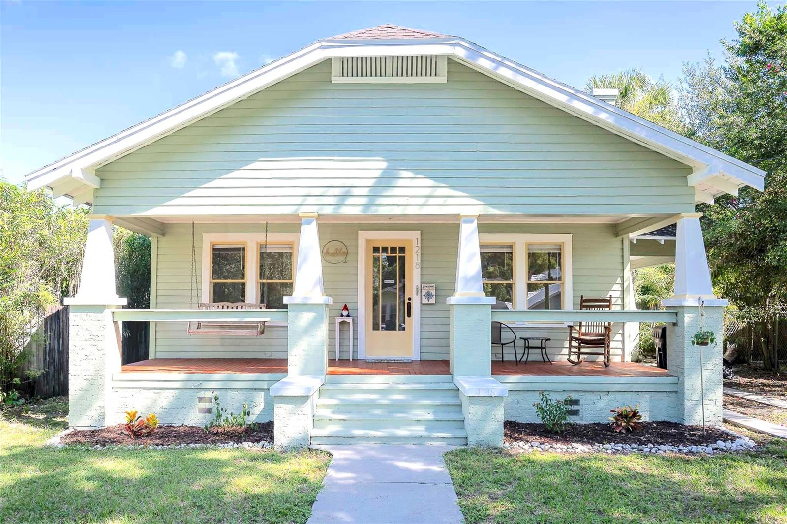 Adorable 2/1 Bungalow in Friendly Hampton Terrace, Seminole Heights Tampa. If you long for simplicity and function as well as thoughtful design, come for a visit! This freshly painted, warm and cozy historic home is cute as a button and has been lovingly maintained while retaining many original features harkening to a bygone era. Imagine pulling up to your home and into the picture-perfect porte-cochere, providing shade and cover during any weather Florida can muster. Don't worry, there's also a new AC system to keep you cool! As you enter here, up the porch steps and through the side door; you'll feel immediately welcomed by the original hardwood floors and built-in wood cabinetry adorning the formal dining area. The adjoining living room is just as lovely and features its own gem: a wood burning, brick fireplace centered among large, wood framed windows. Take a peek from the living room to your ample front porch and think about taking a moment's breath on your porch swing every evening, a hot tea or cold brew in hand. From here, you can greet neighbors as they take their daily strolls or rides and savor a cheery chat with friends or a a peaceful moment alone.
Follow the framed hallway entry to the naturally well-lit bedrooms complete with original windows and low-maintenance wooden floors. Next, take a look at the full bathroom where traditional features meet modern convenience: a pedestal sink, subway tile with sea foam green accents surrounding the tub and a cottage-sized shower window for ventilation and sunlight. Built-in shower and bathroom shelving provide quick access to your fresh towels and favorite self care products. Head to the easy-care kitchen containing all the stainless steel appliances you can't live without as well as tile flooring and granite countertops, both made for quick clean-up. Connected to the kitchen, you'll find the indoor laundry room (washer and dryer included!) with plenty of space for a reading nook, quiet seating area with lots of plants or additional storage overlooking the back deck and Florida-friendly yard. Want to sit outside but desire a bit of privacy? No problem! You can enjoy the sunshine and breeze on the back deck or in your spacious, fully fenced back yard. All that's missing is a fire pit and you! And did you know Hampton Terrace falls within the legal Accessory Dwelling Unit (ADU) boundary? It's true! That means that with some careful research and design, you can convert or expand the existing storage shed to accommodate an in-law or family member suite. Of course, this shed would also be ideal for your bikes, lawn care equipment, holiday decorations, an artist studio or she-shed getaway! This cozy house packs in all the best of a charming historic home with the ease of modern conveniences. And if you enjoy friendly neighbors, local breweries, great food, oak-lined streets and walkable parks along the Hillsborough River, you can't go wrong! Add to that this beautiful bungalow's proximity to Downtown Tampa, Armature Works, The Riverwalk, the University of South Florida and local attractions like the Tampa Zoo and Busch Gardens, you'll always have a fun event to attend! Schedule a visit and experience one of the most loved neighborhoods in Tampa for yourself. The front porch swing beckons!