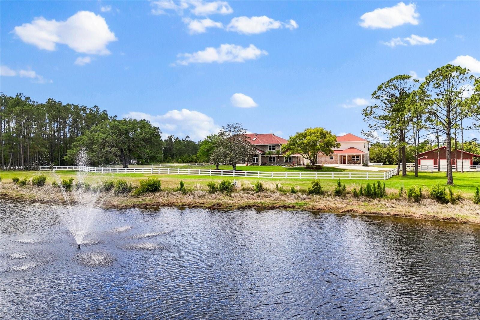 Welcome to your own slice of paradise! Tucked away on 10 breathtaking acres of Florida countryside, and a short 15-20 minute drive to the white sand beaches of New Smyrna Beach, this extraordinary estate invites you to slow down, stretch out, and savor life at its finest. Whether you're dreaming of a multi-generational homestead, a private retreat for guests, or simply a place where serenity meets sophistication, this property has it all—and more. The main home is a harmonious blend of elegance and comfort. Step inside and feel instantly at ease as rich wood and sleek tile floors guide you through light-filled spaces—no carpet, just timeless design and easy living. With 3,766 sq. ft., four spacious bedrooms, a dedicated office, and four full bathrooms, there's room for everyone to find their place. Every bedroom boasts custom-built closets, offering both charm and functionality. The open-concept layout flows effortlessly from the gourmet kitchen—a chef’s dream with its induction stovetop, convection microwave, and abundant prep space—to the inviting family areas perfect for cozy evenings or lively gatherings. Head upstairs to a loft-style game room, ideal for movie nights, gaming marathons, or simply lounging with loved ones. As the seasons change, enjoy the warmth of the fireplace—electric for convenience, wood-burning ready for that authentic crackling glow. Thoughtful touches like crown molding, a laundry chute, and three A/C units ensure both beauty and practicality throughout. Just steps away, the guest house is its own cozy retreat, complete with 1,981 sq. ft., three bedrooms, 2.5 bathrooms, and all the comforts your visitors could hope for. Whether it's family staying for the holidays or friends enjoying a weekend getaway, everyone will feel right at home. Outside, the estate truly comes alive. Three fenced pastures provide ample room for horses or livestock, while a clever rainwater pump system keeps the scenic pond thriving year-round. Take a dip in the solar-heated/electric heated pool, surrounded by lush, manicured landscaping and plenty of room to dine, relax, and entertain under the sun or stars. Rest easy knowing there is a whole-house generator on the guest house powered by a 500-gallon propane tank keeps the lights on and the comfort flowing, no matter the weather. With newer Hardie board siding and soffits, this home is as durable as it is beautiful—built to last, and built to love. This rare gem offers a peaceful, private lifestyle without compromise. Whether you're envisioning family gatherings under open skies, peaceful mornings by the pond, or evenings filled with laughter by the fire—this is more than a home. It’s a lifestyle. Come experience it for yourself. Schedule your private tour today and discover the warmth, space, and possibility waiting for you. Notable updates: Pressure tank for well: 11/2024, Water softener: 11/2016, Electric pool heater: 12/2022, Pool pump: 12/2019, Solar pool heater: 11/2017, Pool resurface: 5/2012, Main house: Two main A/C units: 7/2023, Office min split A/C: 4/2019, Water heater: 10/2018, Garage door lifts: 10/2019, Septic: 12/2020, Guest house: Generator, two A/C, septic: All 8/2018, Main house windows: 2018, Barn Garage doors and lifts: 10/2019