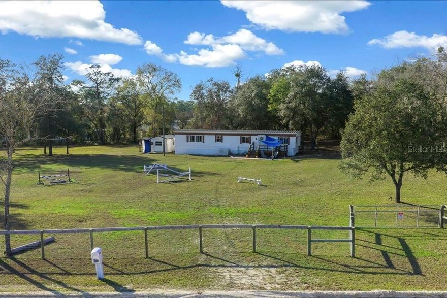 Enjoy peaceful country living just outside the city with this versatile mini farm set on 2.5 fenced, high & dry acres. With No HOA or deed restrictions, this offering allows true freedom of use and ownership. The land includes a solid 2 bedroom, 2 bath mobile home with approximately 840 Sq.Ft. of living space, making it well suited as a primary residence, weekend retreat, or income producing rental. For equestrian use, the acreage is thoughtfully arranged with a large paddock, run in shed, and a flat grassy riding area, offering practical space for horses. In addition, the land includes a chicken coop, fire pit, and a small pond, creating a peaceful outdoor setting for relaxation and enjoyment. The shed on the property equipped with water provides convenient storage for equipment, tack, or tools. Located just 5.7 miles from Goethe State Forest, owners enjoy easy access to miles of scenic horse and ATV trails. The location is approximately 18 miles from the World Equestrian Center and 15 miles from the HITS Horse Show Grounds, offering excellent proximity to major equestrian venues. Beyond its equestrian appeal, the area provides outstanding recreational opportunities, with Rainbow Springs and Devil’s Den just 15 miles away for swimming, kayaking, and outdoor adventure. The Gulf Coast is approximately 23 miles away, while the Atlantic Coast is within 105 miles, making day trips to the beach easily accessible. As an added bonus, this mini farm is currently income producing, with one side of the home operating as an Airbnb, a revenue producing farm stand, and an established Harvest Hosts location for RV renters, offering multiple income streams in a highly desirable Central Florida location. Schedule your private showing today!