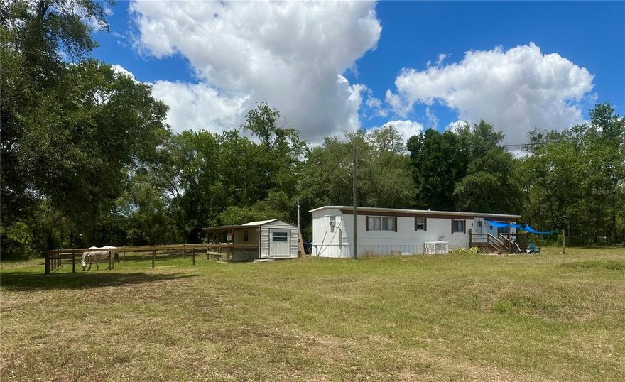 Enjoy peaceful country living just outside the city with this versatile mini farm set on 2.5 fenced, high & dry acres. With No HOA or deed restrictions, this offering allows true freedom of use and ownership. The land includes a solid 2 bedroom, 2 bath mobile home with approximately 840 Sq.Ft. of living space, making it well suited as a primary residence, weekend retreat, or income producing rental. For equestrian use, the acreage is thoughtfully arranged with a large paddock, run in shed, and a flat grassy riding area, offering practical space for horses. In addition, the land includes a chicken coop, fire pit, and a small pond, creating a peaceful outdoor setting for relaxation and enjoyment. The shed on the property equipped with water provides convenient storage for equipment, tack, or tools. Located just 5.7 miles from Goethe State Forest, owners enjoy easy access to miles of scenic horse and ATV trails. The location is approximately 18 miles from the World Equestrian Center and 15 miles from the HITS Horse Show Grounds, offering excellent proximity to major equestrian venues. Beyond its equestrian appeal, the area provides outstanding recreational opportunities, with Rainbow Springs and Devil’s Den just 15 miles away for swimming, kayaking, and outdoor adventure. The Gulf Coast is approximately 23 miles away, while the Atlantic Coast is within 105 miles, making day trips to the beach easily accessible. As an added bonus, this mini farm is currently income producing, with one side of the home operating as an Airbnb, a revenue producing farm stand, and an established Harvest Hosts location for RV renters, offering multiple income streams in a highly desirable Central Florida location. Schedule your private showing today!