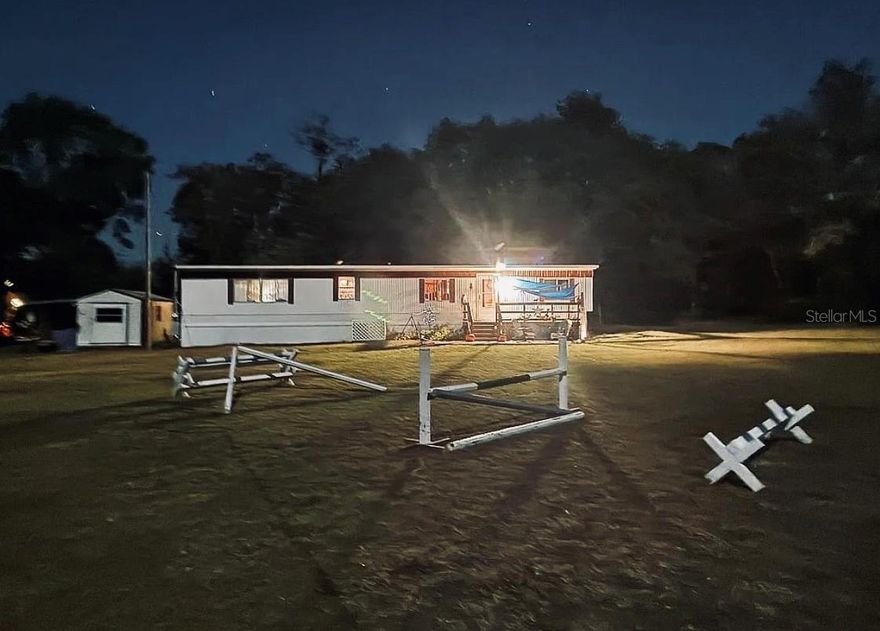 Enjoy peaceful country living just outside the city with this versatile mini farm set on 2.5 fenced, high & dry acres. With No HOA or deed restrictions, this offering allows true freedom of use and ownership. The land includes a solid 2 bedroom, 2 bath mobile home with approximately 840 Sq.Ft. of living space, making it well suited as a primary residence, weekend retreat, or income producing rental. For equestrian use, the acreage is thoughtfully arranged with a large paddock, run in shed, and a flat grassy riding area, offering practical space for horses. In addition, the land includes a chicken coop, fire pit, and a small pond, creating a peaceful outdoor setting for relaxation and enjoyment. The shed on the property equipped with water provides convenient storage for equipment, tack, or tools. Located just 5.7 miles from Goethe State Forest, owners enjoy easy access to miles of scenic horse and ATV trails. The location is approximately 18 miles from the World Equestrian Center and 15 miles from the HITS Horse Show Grounds, offering excellent proximity to major equestrian venues. Beyond its equestrian appeal, the area provides outstanding recreational opportunities, with Rainbow Springs and Devil’s Den just 15 miles away for swimming, kayaking, and outdoor adventure. The Gulf Coast is approximately 23 miles away, while the Atlantic Coast is within 105 miles, making day trips to the beach easily accessible. As an added bonus, this mini farm is currently income producing, with one side of the home operating as an Airbnb, a revenue producing farm stand, and an established Harvest Hosts location for RV renters, offering multiple income streams in a highly desirable Central Florida location. Schedule your private showing today!