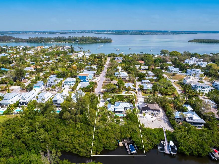 Located on a serene mangrove-lined bayou in the Village of Longboat Key, on a lushly landscaped half-acre site, this cherished 3 bedroom/2 bath Whitney Beach cottage has been lovingly reinvented from top to bottom. The modern coastal cottage imparts warmth immediately upon entry, with tongue and groove heart-pine floors, pecky-cypress walls, and light-filled spaces throughout. Every aspect of the home has been carefully curated with meticulous renovation, staying true to its distinctive history while modernizing the structure and space with a focus on quality, safety, and comfort. Upgrades include a new metal roof (2023,) PGT impact windows, updated electric, lighting, and HVAC, tankless water heater, and the addition of a garage and boat dock. 
A well-equipped chef’s kitchen prioritizes both function and aesthetics, with Cucine Ricci Italian cabinetry, open shelving, 2 Miele ovens, 6 burner Viking gas range, Liebherr refrigerator, wine cooler, deep stainless-steel sink, generous workspaces, soapstone countertops, and a custom-crafted living edge hardwood bar top. 
Through a wall of French doors, the inviting dining area opens to a 1,200 square foot raised Cumaru deck with a protected pergola, saltwater pool and spa, as well as sitting, sunning, and cooking areas. The outdoor space beautifully extends the interior living area, showcasing the tropical landscape as an ideal retreat for personal relaxation or gathering friends. 
The primary ensuite is serene and spacious, with a glass-enclosed shower and soaking tub, ample walk-in closet, access to the outdoor deck, and adjacency to the home's well-equipped laundry room. Two guest rooms with a full bath are conveniently located on the opposite side of the home, creating privacy and comfort for family and guests. 
Ideal for boaters, kayakers, and cast netters, the western edge of the property features a recently constructed Brazilian hardwood boat dock with a 10,000-pound lift to accommodate vessels up to 30 feet, plus a large "floating" dock for kayaks, paddle boards, and other water toys. 
The numerous accolades for this historically significant cottage include a feature in Sarasota Magazine, the 2019 Florida Native Plant Society "Award of Merit" recognizing its Michael Miller-designed 100% native landscaping, and its selection as a feature property for the Longboat Key Garden Club Tour of Homes. 
This timeless Florida-style cottage offers luxurious charm and privacy; many manatees and dolphins call this peaceful bayou home. Grab your golf cart, your bicycle, or your flip-flops - in minutes you'll be enjoying one of the most pristine powder sand beaches in the region, the open bay, and the popular restaurants and shops of Longboat Key.