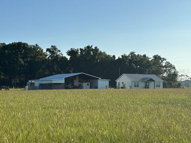 CHIEFLAND, FLORIDA - BRAND NEW 2024 home on 10+ acres (approx) with additional barn living quarters under expansive 60 x 65 foot pole barn FOR YOU AND YOUR HORSES OR CATTLE ~ Currently 3 stalls in place with tack room/workshop and TONS of extra room for additional stalls, horse trailer, RV, or covered parking. Everything is new, barely lived in, open floor plan with 9+ foot ceilings with beautiful tongue and groove pine wood cathedral ceilings showplace the living area with plenty of room for entertaining. A large picture window over the farm kitchen sink provides a panoramic view of the lush green back pasture while the living room French double-door entry provides a panoramic view of the expansive front pasture. The home is a split floor plan which was well thought out and flows effortlessly from one end of the house to the other. Huge laundry room has lots of built-in storage and connects to guest bathroom and bedroom. All kitchen appliances are stainless steel and include a commercial stove, microwave hood, and dishwasher. A large pantry with lots of shelving and electrical outlets to plug in your cell phone and Milwaukee drill is also a nice feature. The master bedroom has a large walk-in closet and a second closet houses a chest bureau with overhead storage and room to hang long wardrobe items. The custom master bathroom has an enormous walk-in porcelain-tiled shower with dual shower heads and plenty of room for shower controls and hanging towels at shower entry, which is SO convenient! No carpet in home, all flooring is luxury waterproof vinyl planking. Main home A/C is Trane and house has been wired for whole home generator system. The barn living quarters are air-conditioned/heated with mini-split system and includes bedroom area, refrigerator/microwave, and full bathroom with included laundry room encompassing another washer & dryer and hanging closet storage. The sellers actually lived here quite comfortably while their house was being built. An ADT security system is installed in both the main home and barn living quarters. Outside the living quarters is a covered open porch approx 190 sf which is being used as a summer kitchen, barbeque area. There is a small covered patio at the French door entry and a larger covered porch at the kitchen entry with an outdoor shower and walkway which leads to the barn living quarters. There are currently 3 stalls with walkouts to pasture areas. A tack room/workshop is adjacent to the stalls and there is also an additional storage shed with electric. The farm is fully fenced around the perimeter with a locking front gate, and interior cross-fencing is provided with Cashman's Zareba heavy duty rope 10-mile electric fencing making it easy to reconfigure your fencing for rotating pastures. Also includes set up round pen with extra bright LED arena lights. This property is located in an area of other large very nice agricultural properties. Not far from Fowler's Bluff famous Treasure Camp Restaurant and new boat ramp on the Suwannee River. Numerous pristine freshwater springs nearby, approx 10 minutes to Chiefland Walmart, 45 minutes to Gainesville for state of the art medical care, and 45 minutes to Ocala's newest sensation, the World Equestrian Center for the best in equestrian competition & fabulous eateries and shopping! An appointment is needed to see this property because there is so much to see! Front adjoining ten acres all in pasture is also listed for sale separately or together.