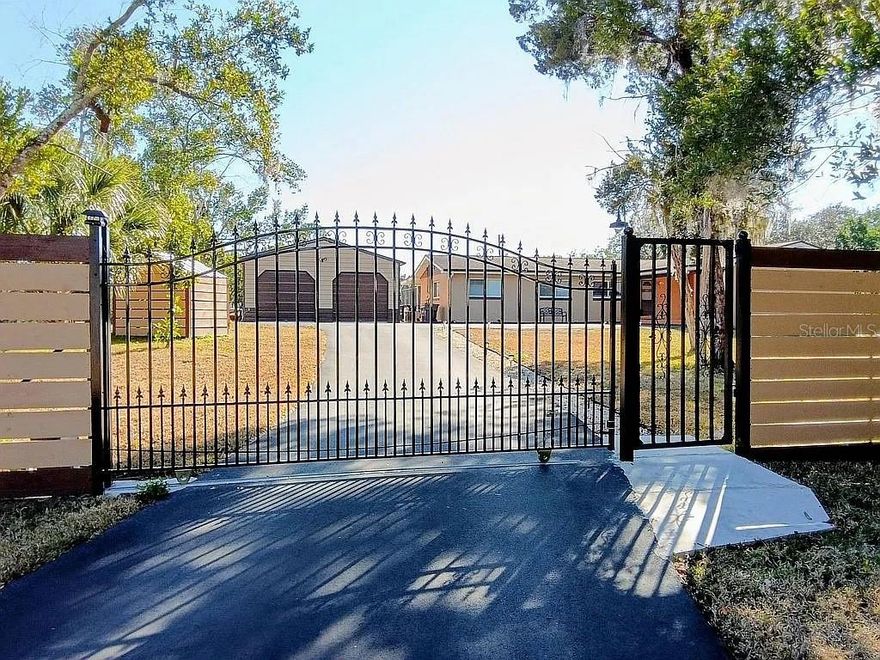 At the very end of a secluded roadway sits a private 1.61-acre retreat offering space, security, and flexibility rarely found this close to town. Surrounded by open land and mature surroundings, this solidly built concrete block residence delivers three bedrooms and three full baths with a layout designed for comfort and function.

Natural light fills the main living area through expansive windows that frame wide, uninterrupted views of the property. The kitchen serves as the heart of the home with marble surfaces, updated appliances, and generous workspace. Wood flooring extends throughout, and each bathroom features modern walk-in showers for a clean, streamlined feel.

Outdoors, the setting transforms into your own recreational compound. A 40' x 15' pool with dedicated heat pump allows for extended seasonal use, while the covered porch provides the perfect vantage point to enjoy the peaceful surroundings. The detached oversized garage/workshop, additional covered parking, new asphalt drive, and secure sliding gate create both convenience and privacy.

Infrastructure updates include a 2018 roof, new 4" gutter system, front and back door Ring cameras primary and backup wells, and dual septic systems — offering long-term practicality and independence. The acreage provides room for expansion, additional structures, RV/boat storage, or other future possibilities (buyer to verify).

Located just moments from Parrish Medical Center, Marina Park, and US-1 access, this property combines privacy, land, and accessibility in one distinctive offering.