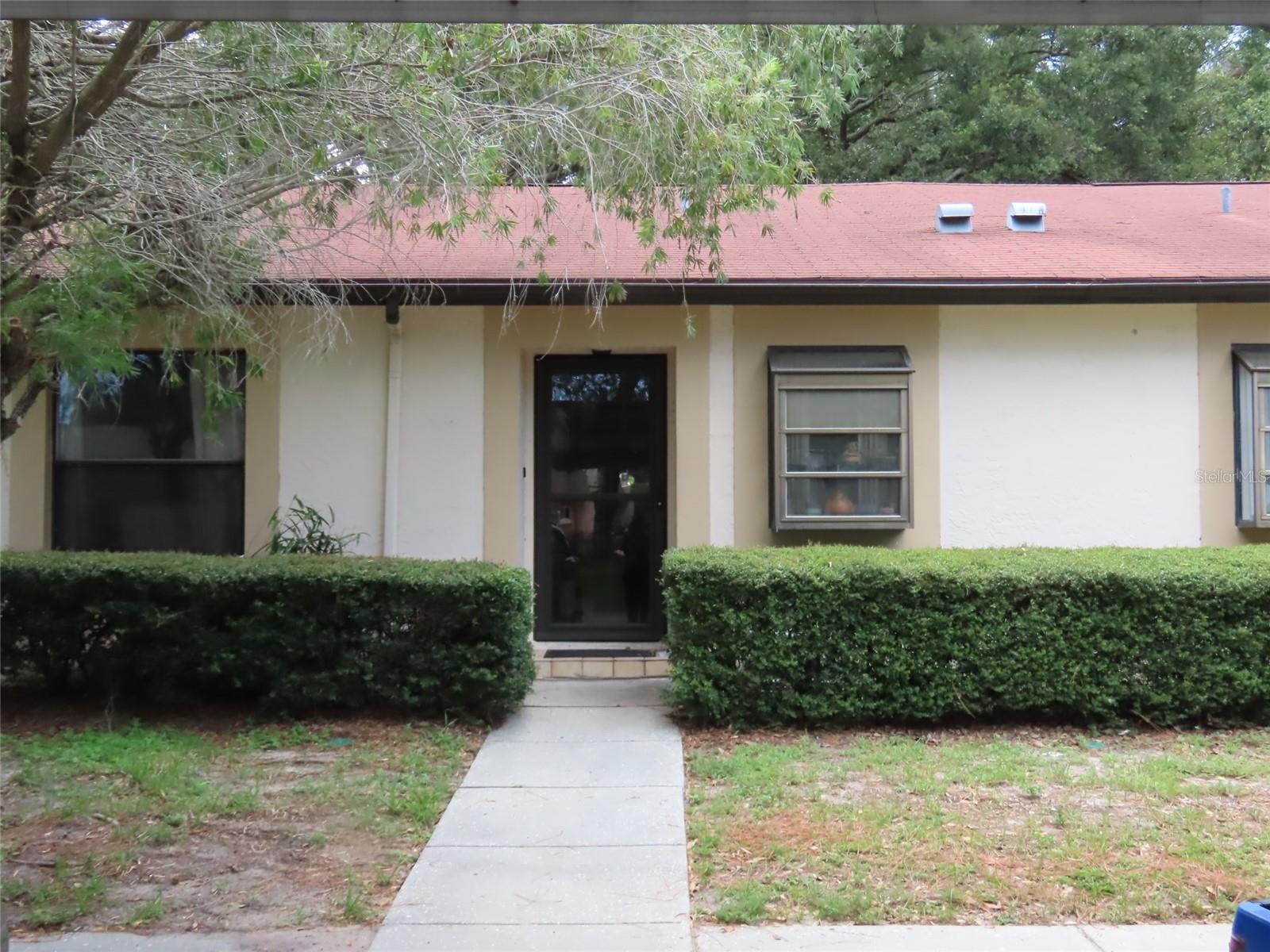 Welcome to Deerwood Gardens, a well-maintained and centrally located community in Largo, where this 2-bedroom, 2-bathroom ground-floor villa presents an excellent opportunity to create your ideal Florida home. Unit 21B features a desirable split-bedroom floor plan, offering privacy for both residents and guests. The primary bedroom is situated at the rear of the villa with its own en suite bathroom, while the guest bedroom and full bath are located toward the front. The spacious living and dining area offers an open-concept layout with laminate flooring and leads to an enclosed rear porch, with storage closet, —perfect for enjoying morning coffee or relaxing with peaceful views of the beautifully landscaped grounds.
While the home is in need of updating, it provides a solid foundation for personalization and value enhancement. Whether you’re a seasonal resident, year-round homeowner, or investor, the potential here is clear. This unit comes with a designated carport located directly in front for ultimate convenience, and the community offers a host of amenities, including a sparkling pool, clubhouse, shuffleboard & tennis courts, and beautifully manicured green spaces. HOA fees include water, sewer, trash, basic cable, internet, exterior maintenance, and more—keeping ownership low-stress and affordable.
Located just minutes from the Gulf beaches, Largo Mall, Seminole City Center, and numerous restaurants, parks, and medical facilities, this property is ideally positioned for both relaxation and accessibility. It is not located in a high-risk flood zone, and the community is pet-friendly (there are pet restrictions) and welcoming to all ages. With its great layout, central location, and potential for improvement, this villa is a smart choice for anyone looking to enjoy the Florida lifestyle while building equity through updates. Information is believed to be accurate but is not guaranteed. Buyers and agents to verify all facts pertinent to their purchase decision.