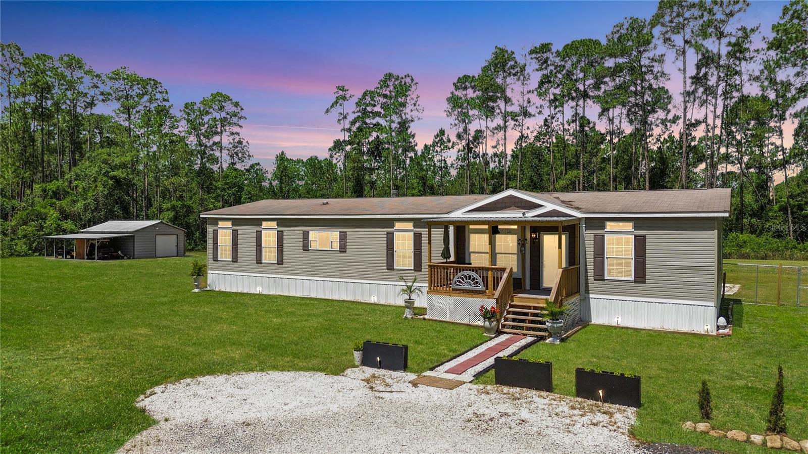 THIS is Modern Farmhouse living at its best! Just 2 miles to shopping, gas, and produce. This 2,327 sq ft 4/2 former model sits on 2.27 high & dry acres in Daytona North. Private, mostly cleared, and well protected by a 6' privacy fence. The front yard seems endless. Unwind in a backyard designed to elevate your evenings. Two decks give you plenty of covered and screened outdoor area. Look to the corner of the property for a fairy garden and running creek. Head inside to find 9-foot ceilings and crown molding, the rustic features of the living area and kitchen are all accented by the wood-burning fireplace. Large primary with private water closet, French doors, and an oversized laundry with wash basin. New A/C, septic, water filtration in 2023. Hurricane windows. Garage w/ 25x18 add-on, 8x12 air-conditioned shed, and generator hookup. Comes with two generators (one whole-home), zero-turn mower, 5×8 trailer, and golf cart—everything you need for country life. Furnishings included! All information pertaining to the property is deemed reliable, but not guaranteed. Information to be verified by the Buyer. Be advised that cameras may exist recording audio and video inside/outside the property, such as ring doorbells. Photos are digitally enhanced and could be altered, please verify.