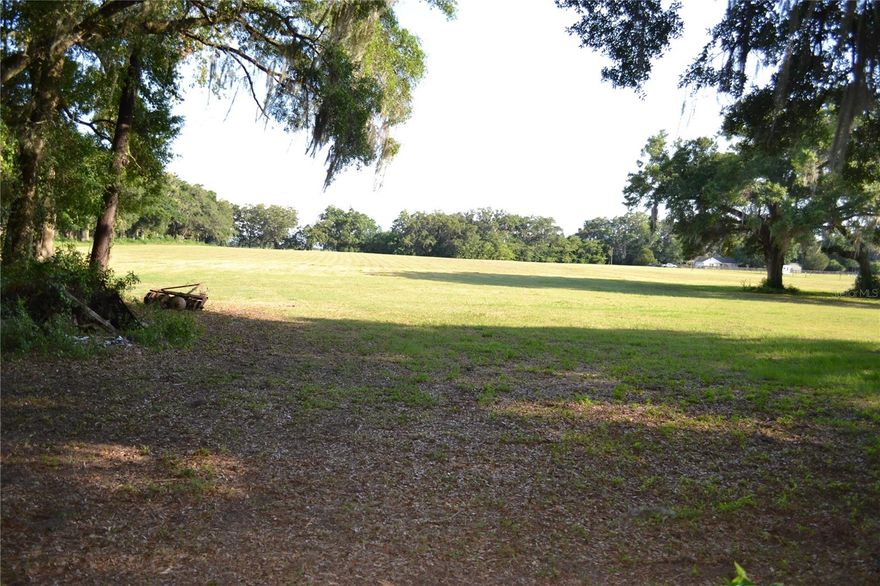 16.74 acres of cleared A-1 zoned pasture land with a 1908 "cracker" style house. House could be restored, but would be quite the undertaking. Land is partially fenced, would be a great mini farm or hay pasture. There are a couple out buildings/sheds and citrus tree. 1 well, 2 septic tanks, Hwy 329 frontage. Come look at your future slice of heaven, peace and quiet abound!!