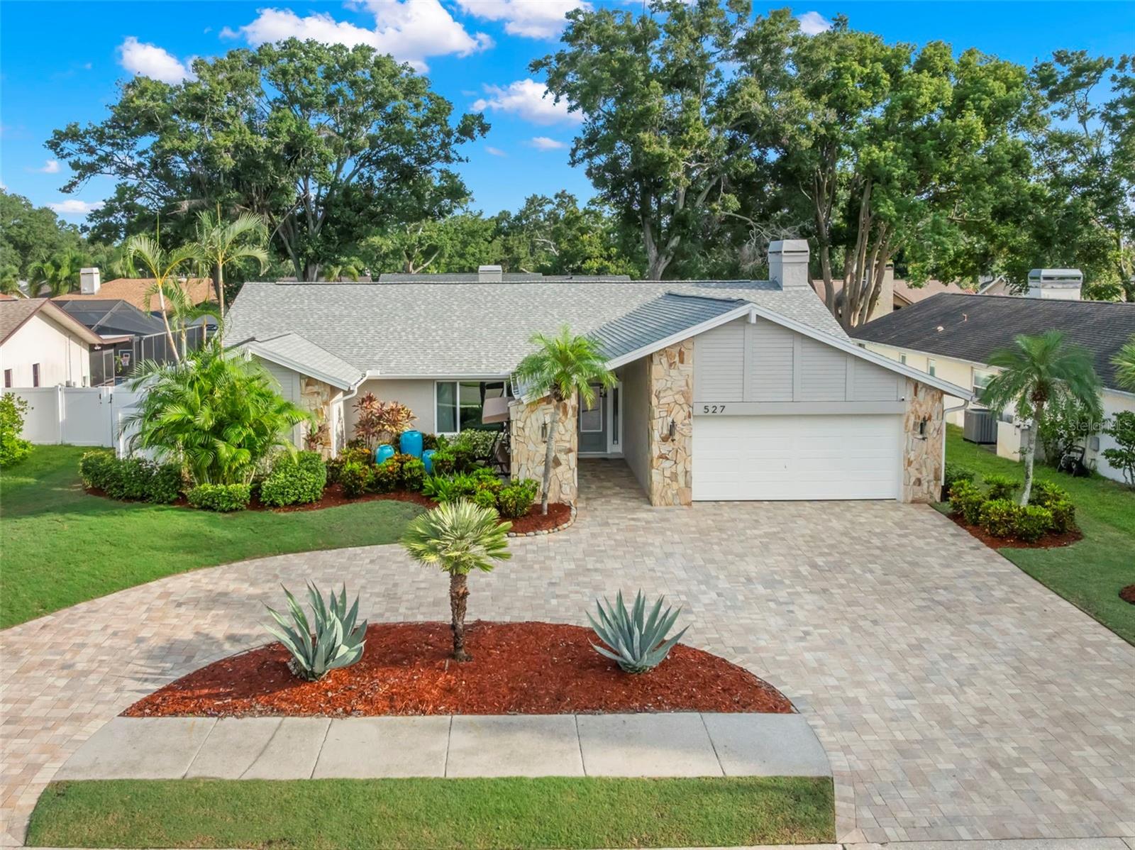Welcome to your dream home in Safety Harbor! This beautifully remodeled single-level 4-bedroom, 3-bath pool home with bonus living space in a non-evacuation zone is just minutes from Philippe Park and vibrant downtown Safety Harbor. From the moment you arrive, the circular brick paved driveway makes a striking first impression and provides both convenience and curb appeal. Inside, you’ll find vaulted ceilings, abundant natural light, and quality upgrades throughout—including new hurricane-rated windows, new HVAC ductwork, 32x32 porcelain tile flooring, and a 2-car garage with epoxy flooring. A beautifully updated kitchen anchors the home with wood cabinetry, stainless steel appliances (built-in oven & microwave, induction cooktop), leathered granite island, and a cozy breakfast nook set beneath impact skylights. Generous wall cabinetry and built-ins keep everything organized. The adjoining family room features a fireplace and custom built-ins; the formal living room wows with vaulted ceilings and a picture window that floods the space with natural light. Your spacious primary suite offers vaulted ceilings, pocket slider access to the lanai, motorized roller blinds for privacy, walk-in closet, a spa-like bath with an oversized shower and a jacuzzi tub—your personal sanctuary at day’s end. A smart split layout provides three additional bedrooms, two updated baths (one with convenient pool access), and an oversized bonus room with French doors— perfect for an office, den, guest suite, or even a 5th bedroom. Step outside to your resort-style pool with water deck jets, a new extended pool enclosure, and shellstone pavers that are both slip- and heat-resistant. The fully fenced backyard features new sod and tropical landscaping. Additional highlights include a laundry room with cabinetry, sink & folding counter and bonus mudroom/storage area with built-ins. Minutes to lively Downtown Safety Harbor, cafés, shops, waterfront parks, and easy access to Tampa, St. Pete, and award-winning beaches— this home offers the perfect blend of modern upgrades, flexible living spaces, and resort-style outdoor living. With its central location and move-in ready condition, this property truly has it all. Schedule your private showing today.