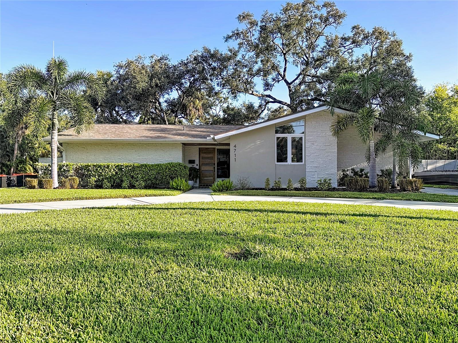 This stunning home perfectly blends mid-century charm with modern luxury. Featuring 3 bedrooms and 2 beautifully updated baths, the home offers multiple living spaces including a family room, formal living room, and dining area. The kitchen is a chef’s dream with an induction cooktop, built-in oven, and microwave drawer, plus an eat-in nook and dry bar for entertaining. The primary suite opens to the back patio through sliding glass doors and includes a large walk-in closet with built-ins, a separate shoe closet, and a spa-like bath with a walk-in shower. Throughout the home, you’ll find top-of-the-line finishes and gleaming hardwood floors. Additional highlights include a large indoor laundry room with ample storage and a beautifully landscaped, fenced backyard featuring both open and covered patios. This home is perfect for relaxing or entertaining. Located in one of South Tampa’s most desirable neighborhoods, this home offers incredible walkability to Mabry Elementary and Coleman Middle.