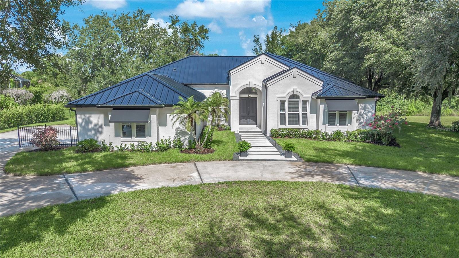 Absolutely stunning, crisp and clean pool home with tall ceilings and lots of land surrounding you in an amazing location! Nestled among majestic mature oaks on a private .74-acre conservation lot in quiet, highly desirable Windermere Reserve with access to the Butler Chain of Lakes. Enjoy serene views from most rooms in this rarely available community. As you enter through a canopy of trees, Windermere Reserve backs onto Lake Down and sits across from Isleworth Golf & Country Club. As a Windermere resident, enjoy 6 lighted tennis courts, parks, playgrounds, frisbee golf, lakefront beaches, and two private boat ramps—Lake Down is just around the corner! Golf-cart friendly town with quaint coffee shops, restaurants, a brewery, farmers market, and seasonal events. This solid block, one-story home has no carpet and features a NEW METAL ROOF, NEW WOOD LAMINATE floors from SPAIN, new interior/exterior paint, fully resurfaced pool with new tile, lighting, and waterfall. New SHELL STONE ENTRY with Spanish tile inlay. Meticulously designed updates throughout including the kitchen, baths, and much more! Spacious layout with high ceilings, open floor plan, 2 primary suites with pool access, office (or 5th bed), large family room with fireplace, and breakfast area all opening to a screened pool atrium and covered patio—perfect for entertaining! Oversized 3-car side-entry garage along with fenced pet area. Minutes from Dr. Phillips, Bay Hill, Restaurant Row, and theme parks. Rare opportunity in Windermere Reserve—don’t miss it!